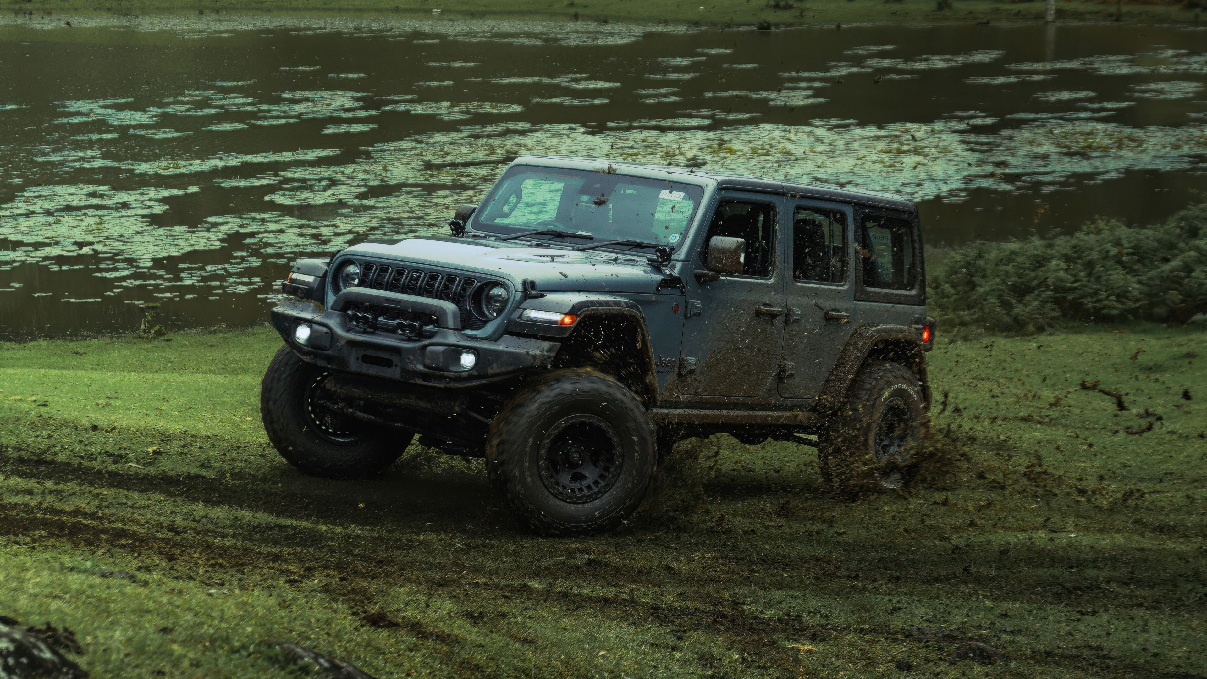 Jeep Wrangler Rubicon offroading in muddy terrain HD Wallpaper