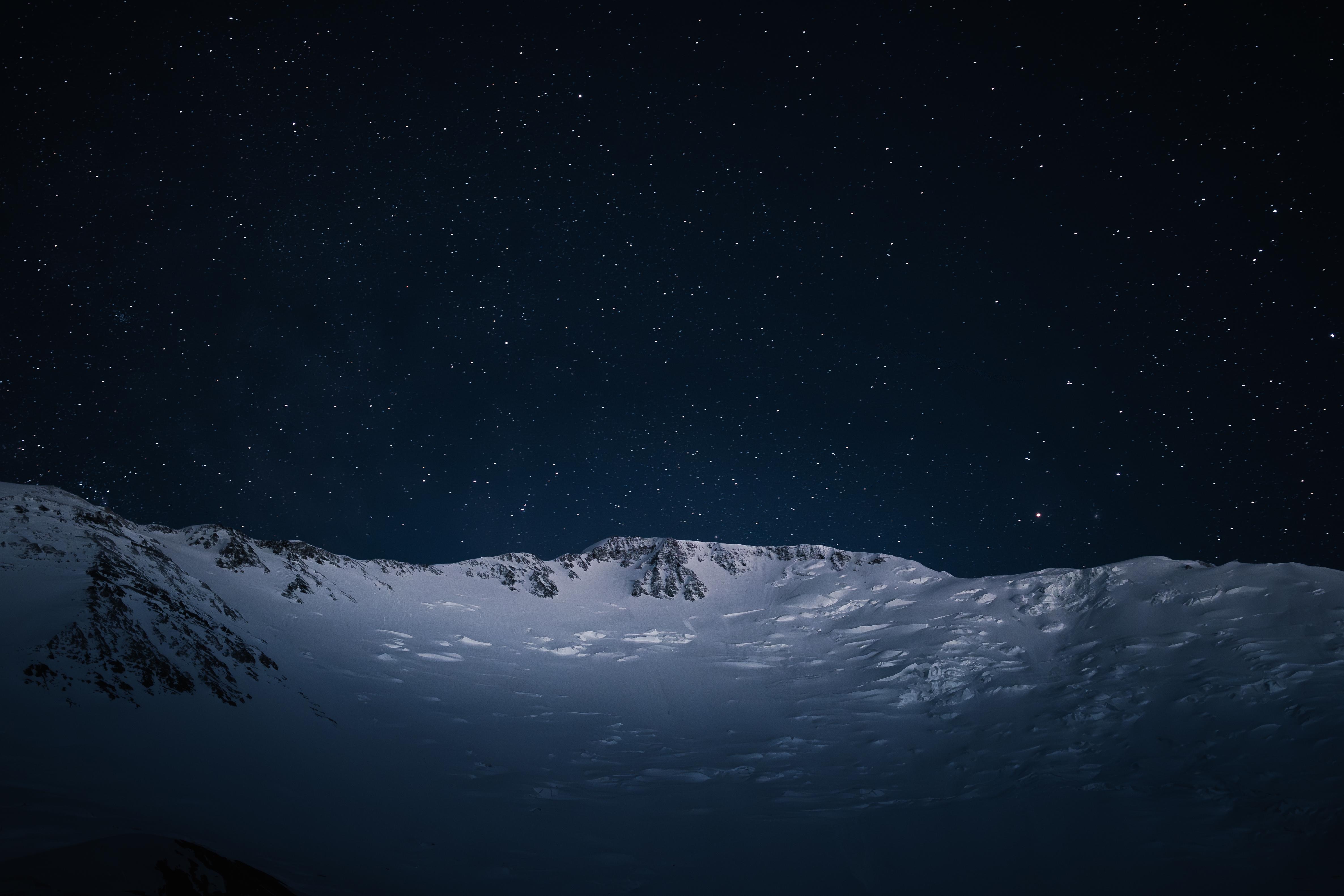 Snowy mountains under a starry night sky HD Wallpaper