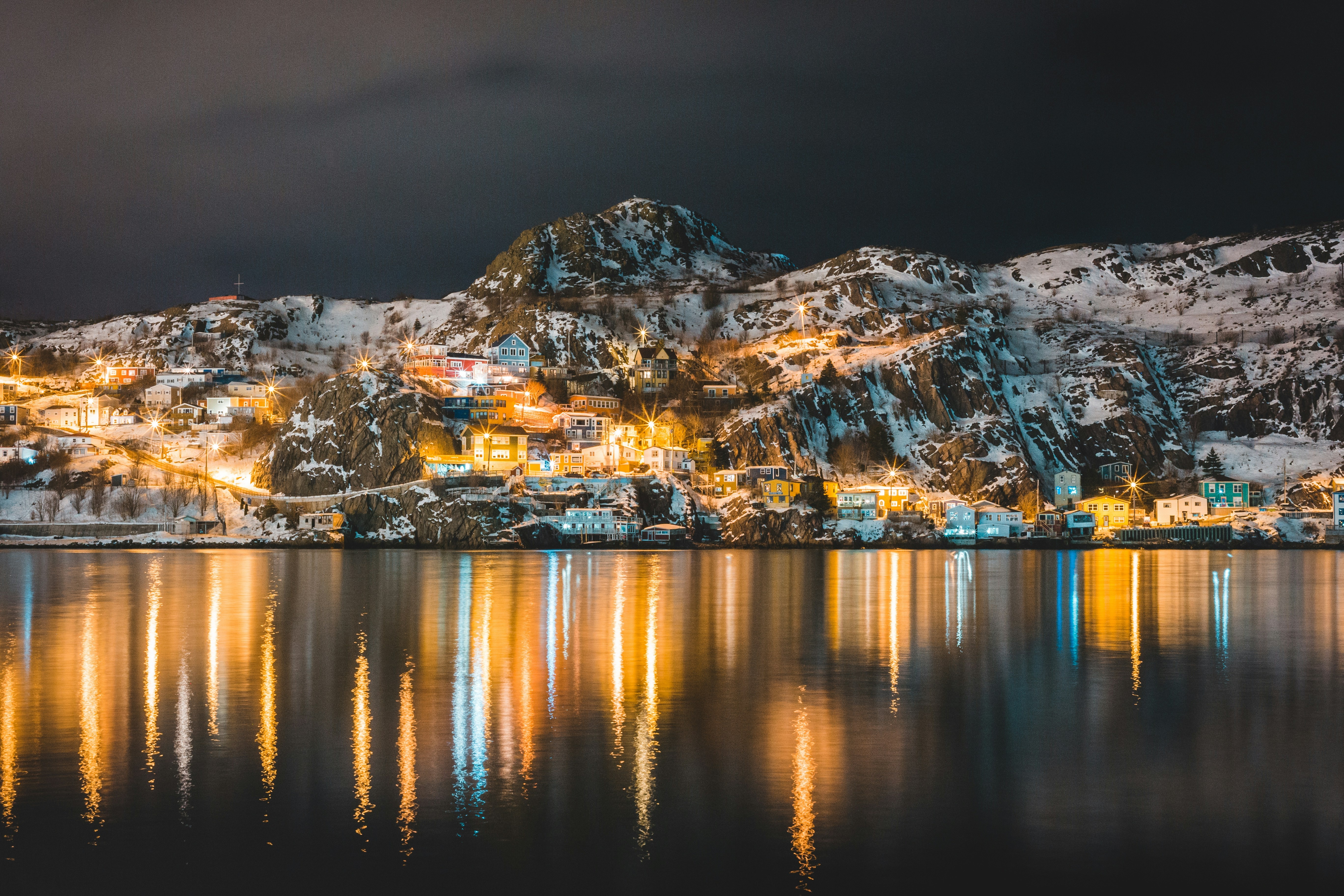 City lights on a snowy mountain at night HD Wallpaper