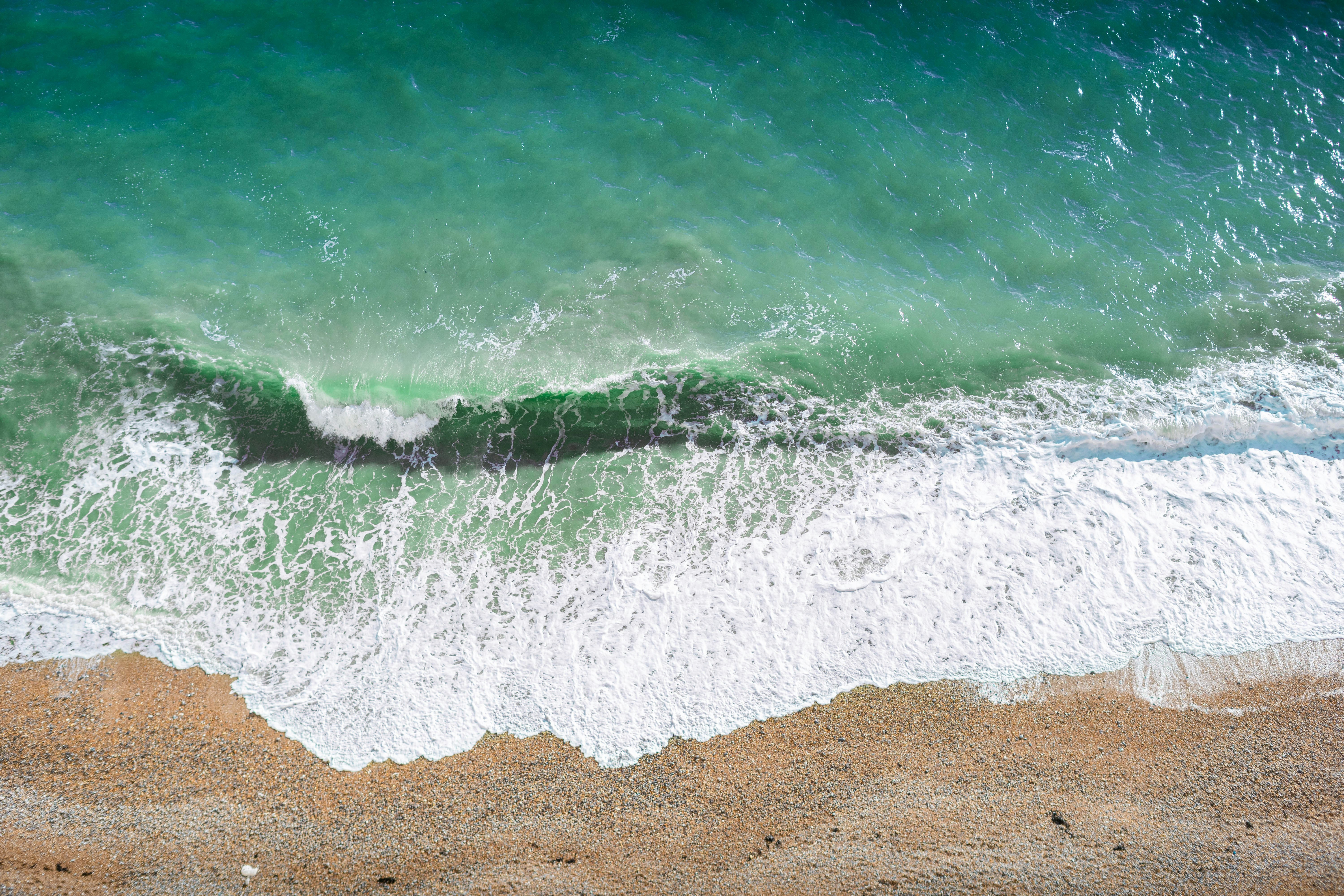 Aerial view of a beach with turquoise ocean waves HD Wallpaper