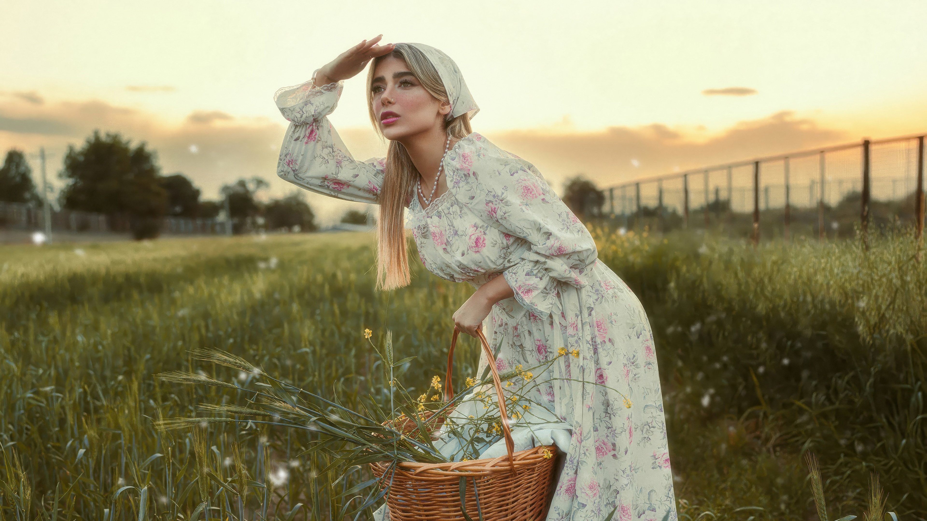 Woman in floral dress in a field at sunset HD Wallpaper