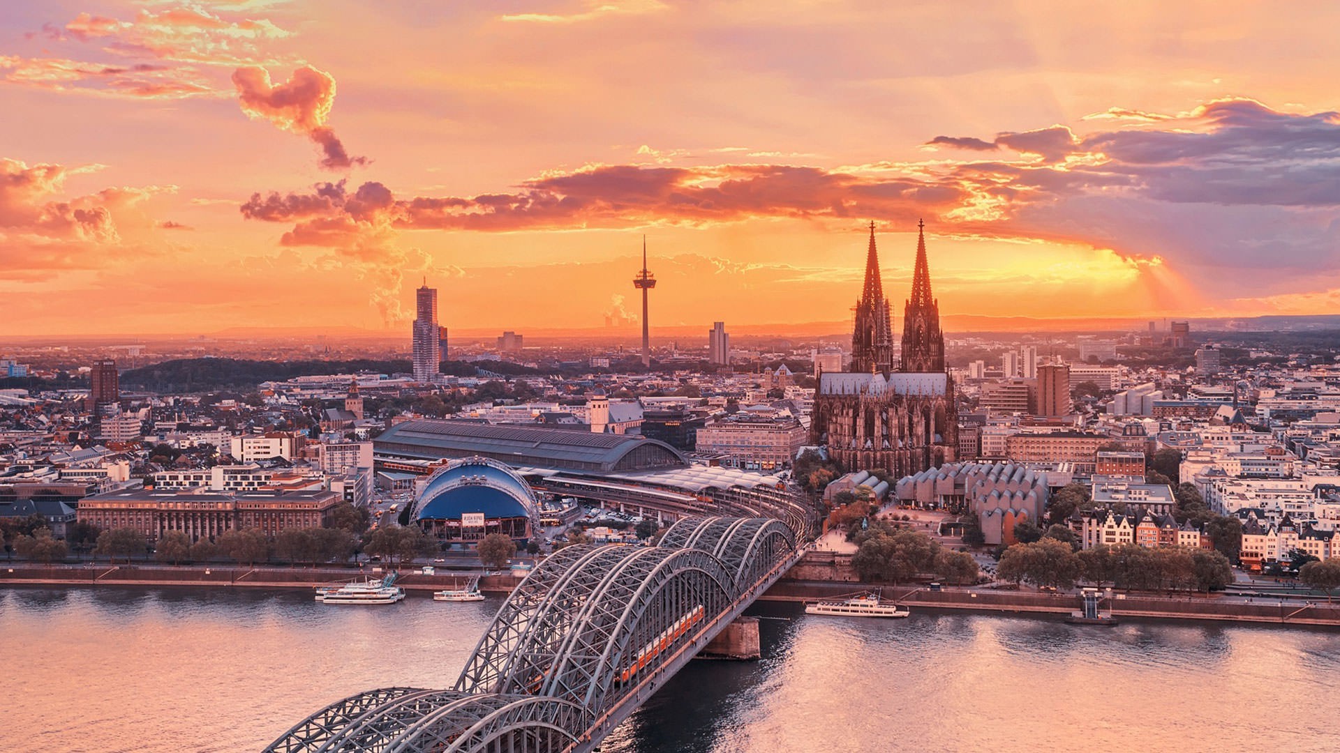 Cologne cityscape with Hohenzollern Bridge and Cathedral at sunset HD Wallpaper