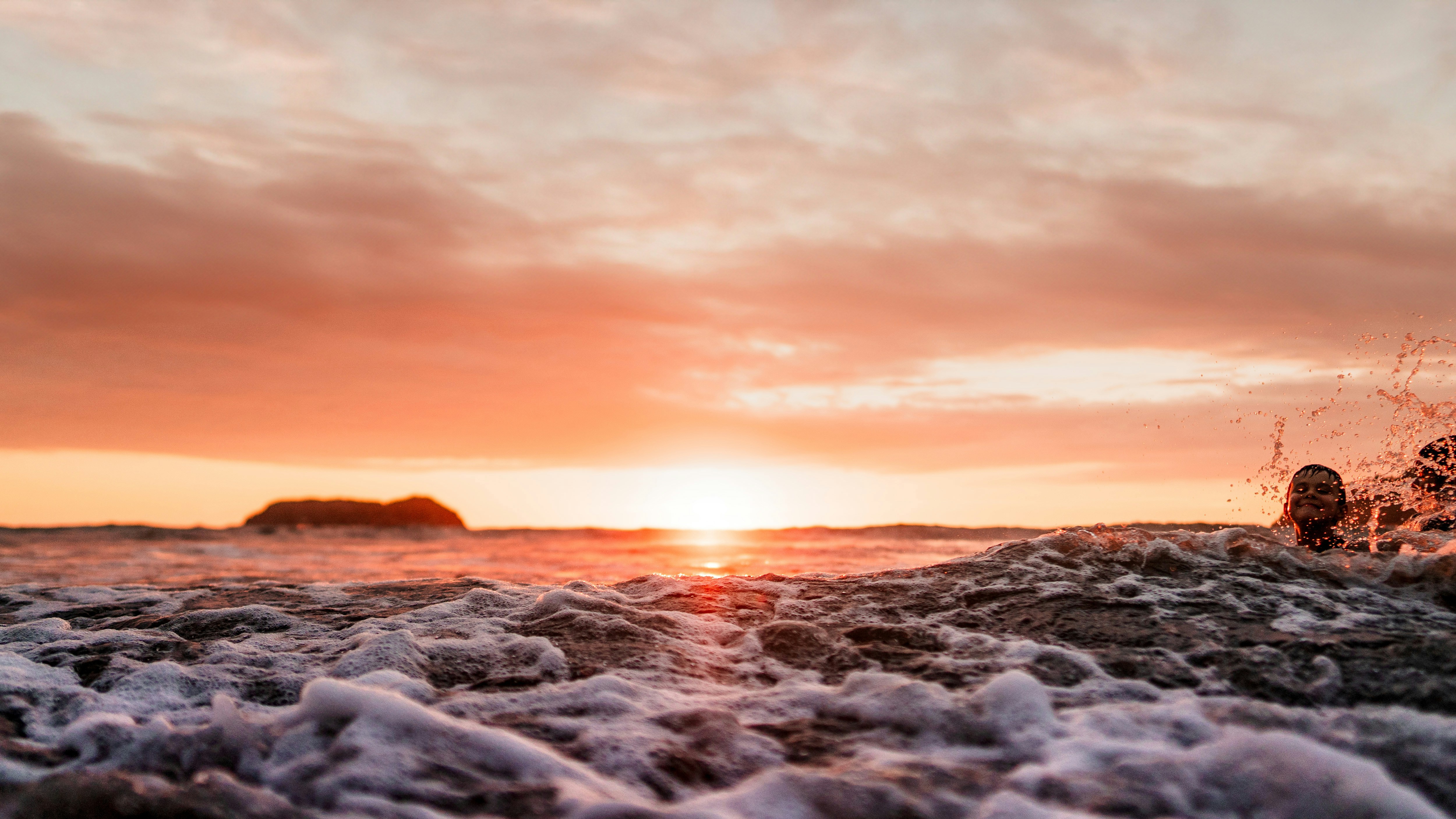 Sunset Over Ocean Waves With People Swimming HD Wallpaper