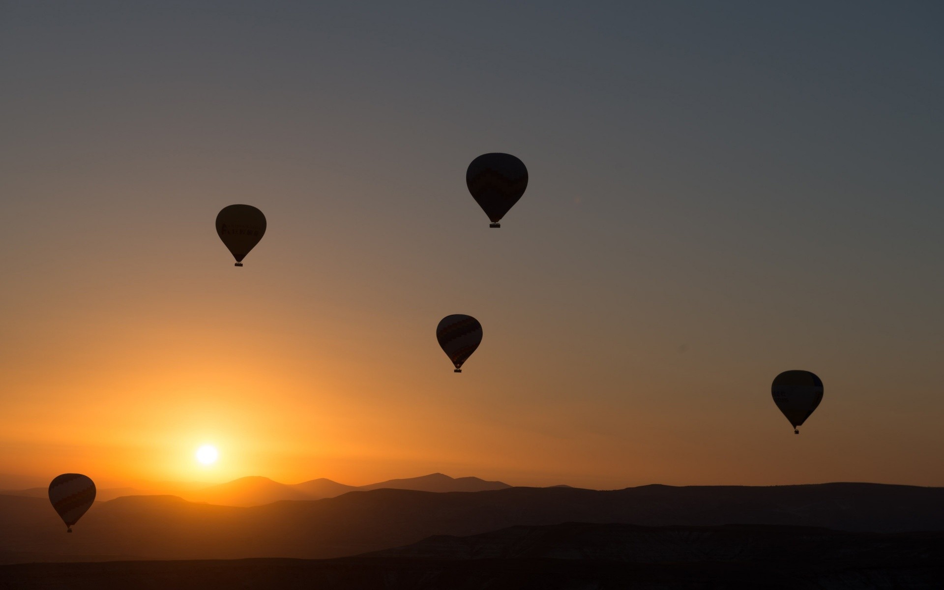 Hot air balloons at sunset over mountains HD Wallpaper