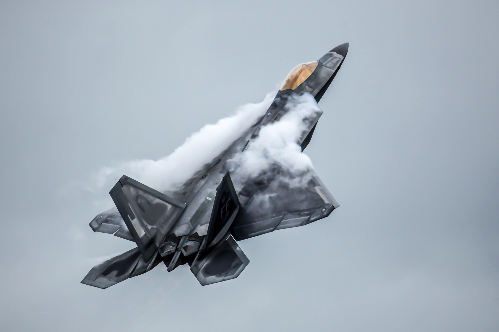 F-22 Raptor performing a maneuver with smoke HD Wallpaper