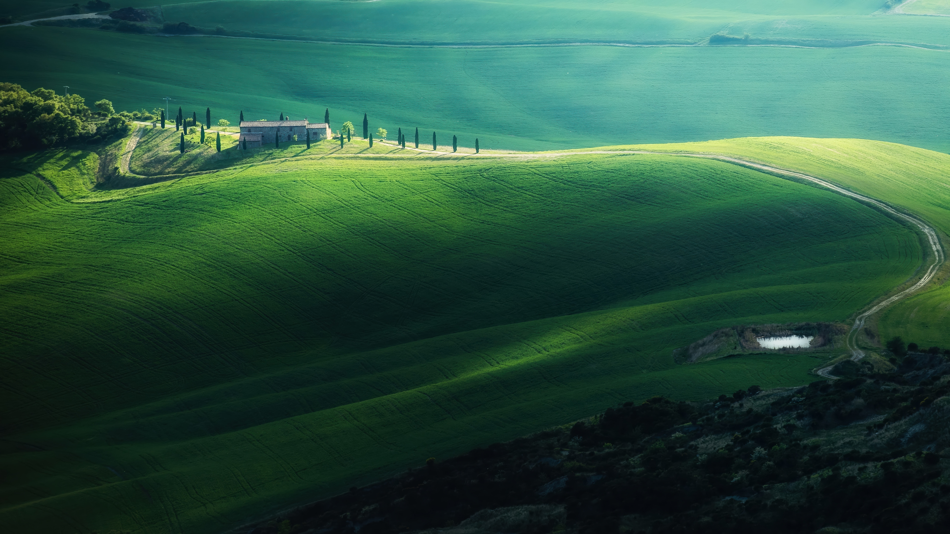 Green rolling hills with a house and cypress trees HD Wallpaper