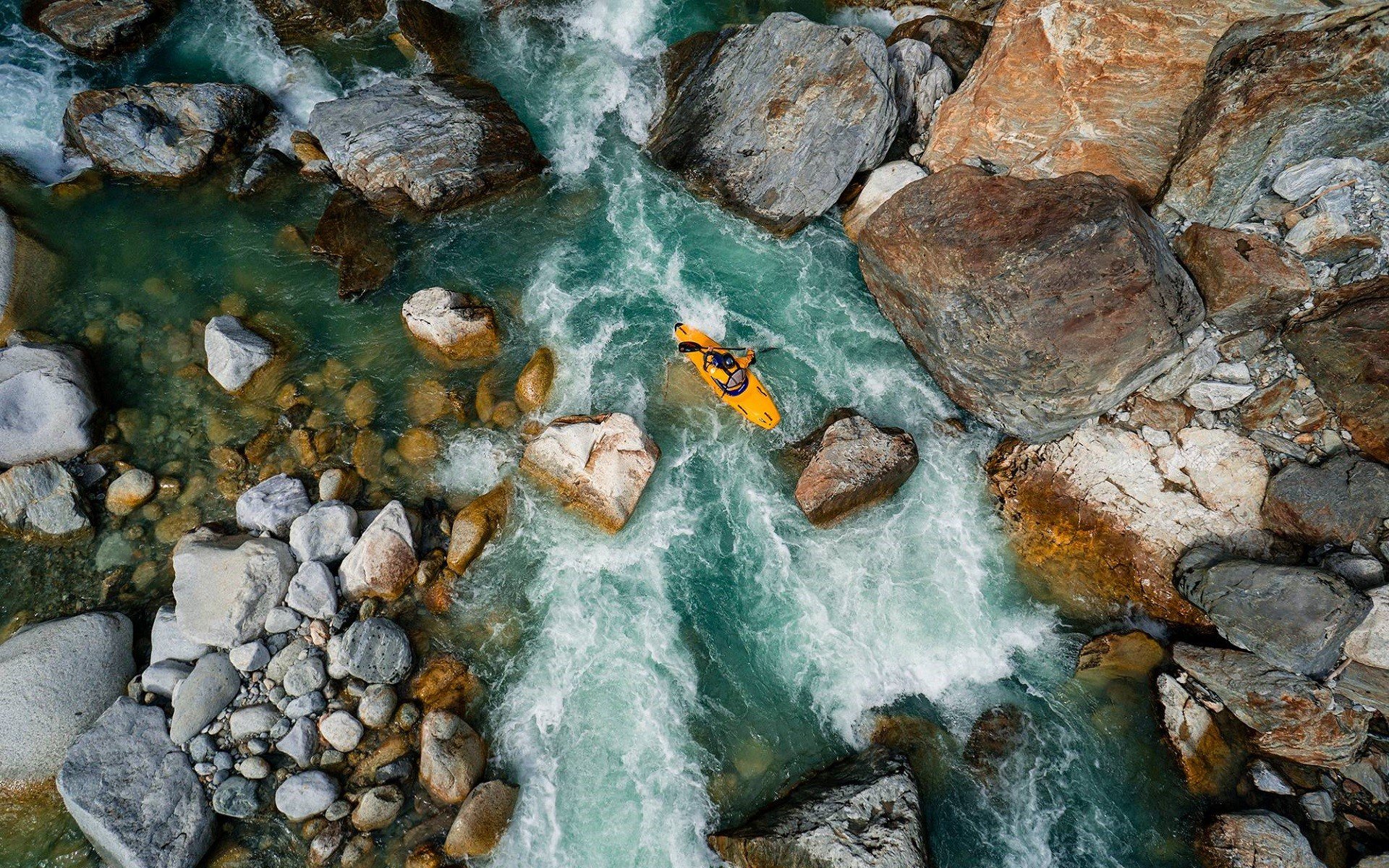 Kayaker navigating a rocky river HD Wallpaper