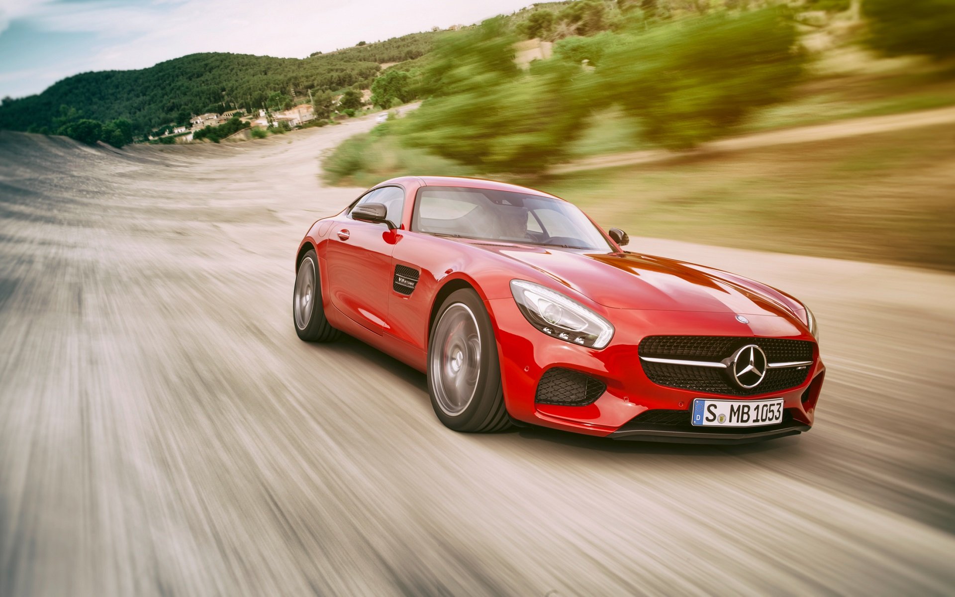 Red Mercedes-AMG GT driving on a scenic road HD Wallpaper