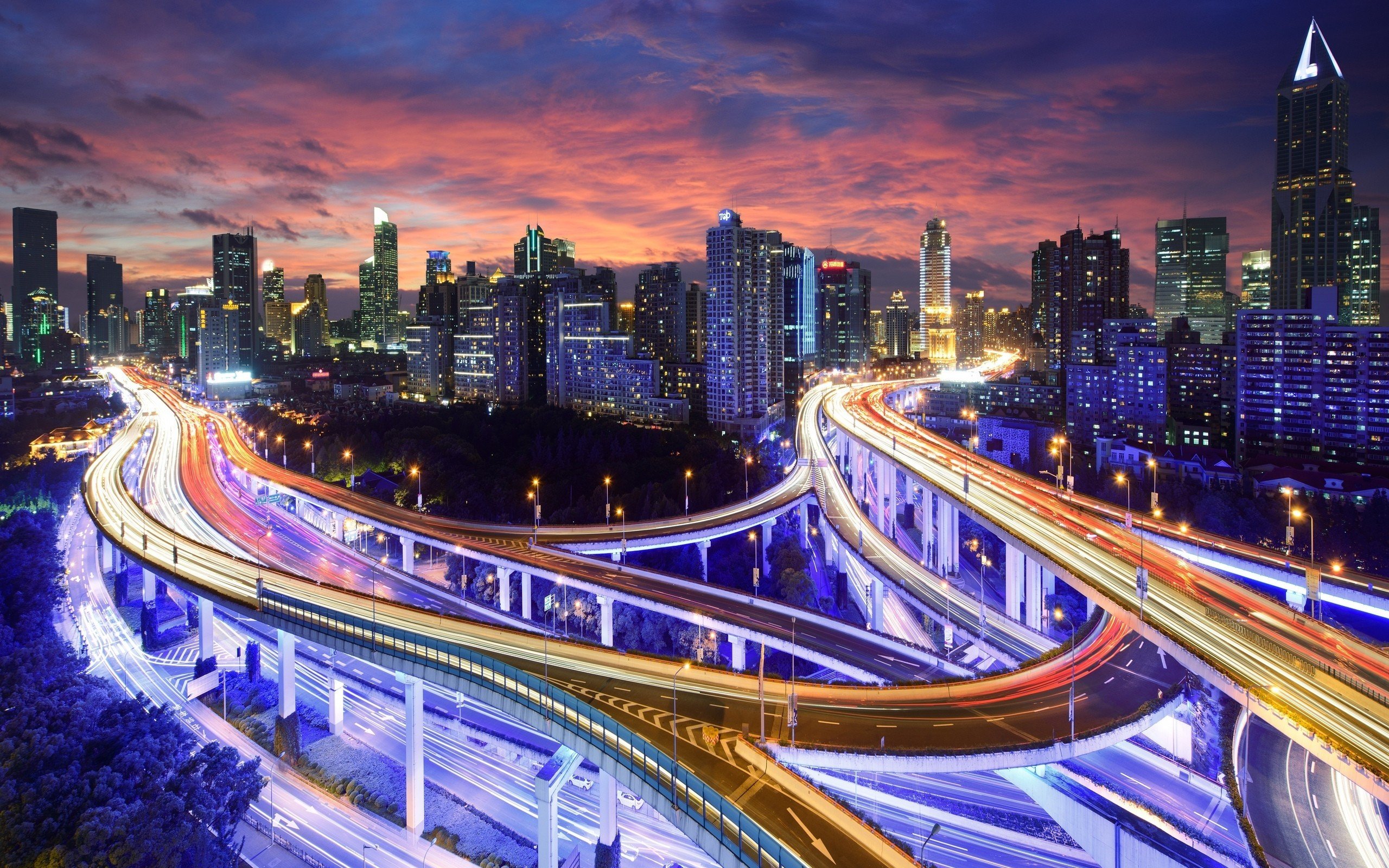 Cityscape with highway at dusk with light trails HD Wallpaper