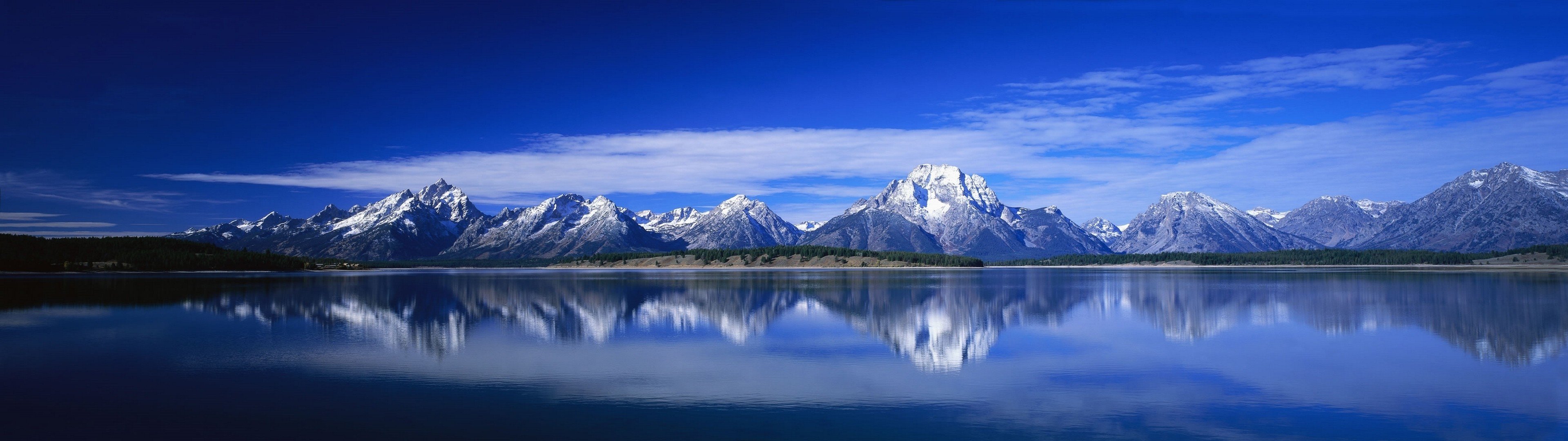 Snow-capped mountains reflected in a lake under a blue sky HD Wallpaper