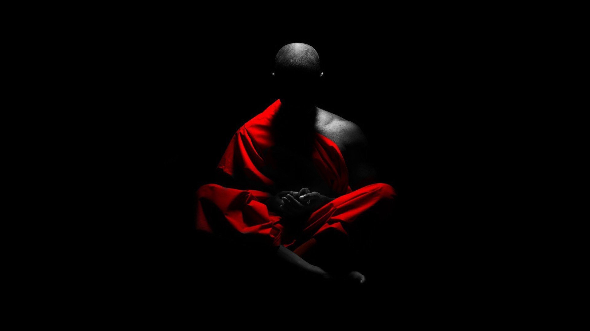 Monk in red robes meditating in darkness HD Wallpaper