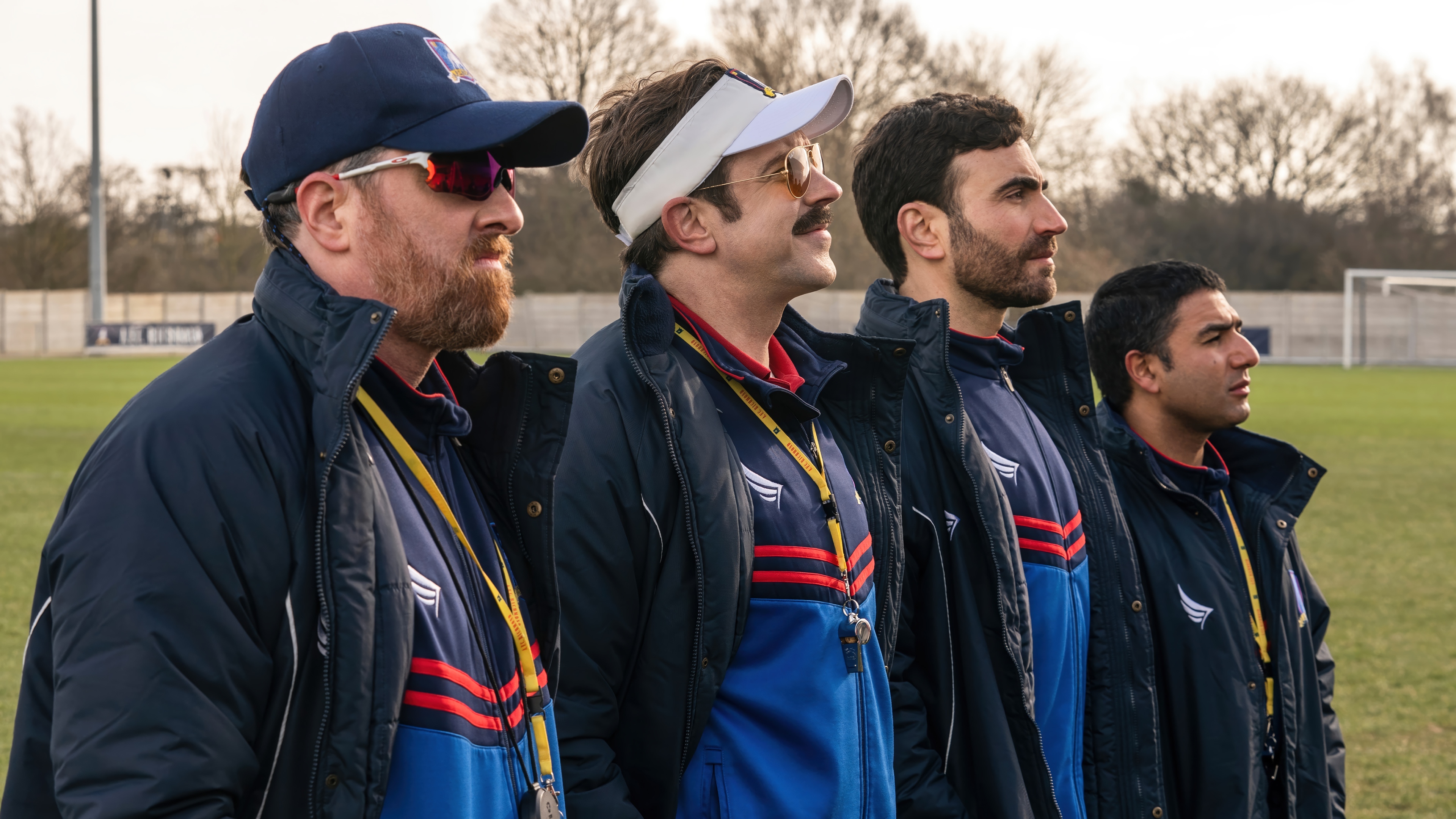Ted Lasso and his coaching staff on a field HD Wallpaper