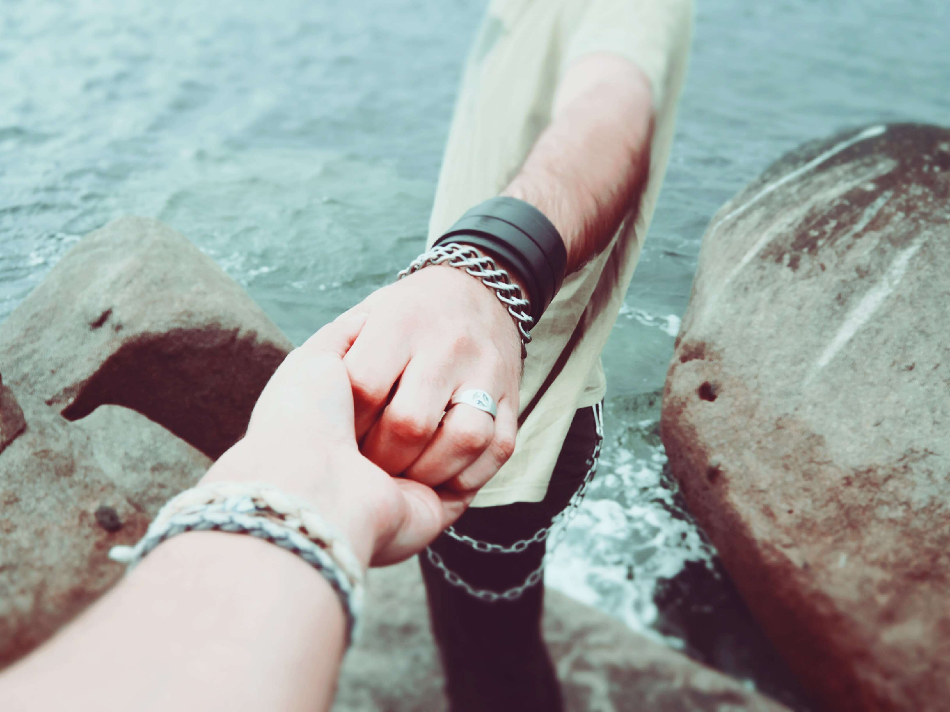 Couple holding hands by the water HD Wallpaper