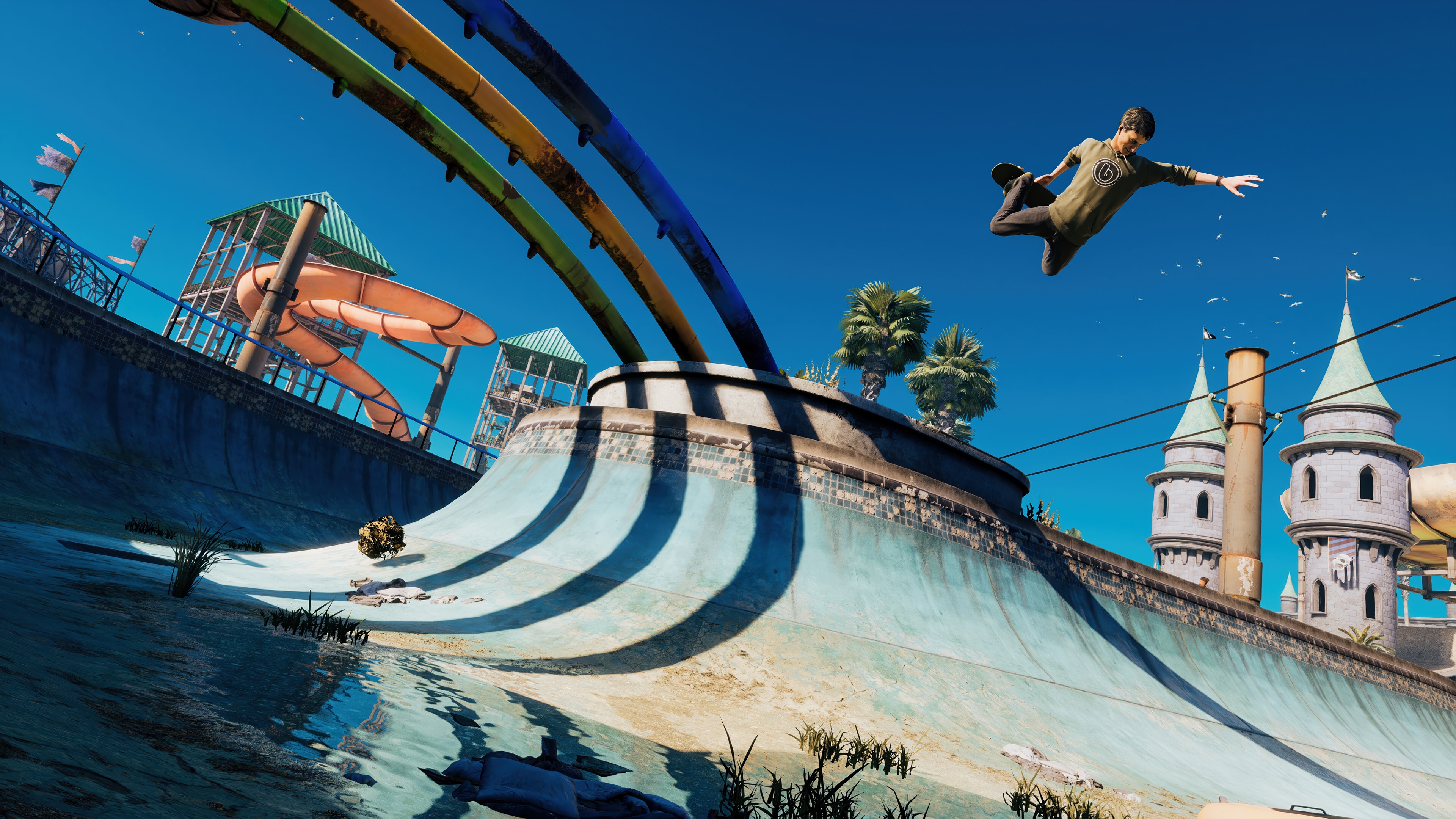 Skater performing a trick in a skatepark with water slides HD Wallpaper