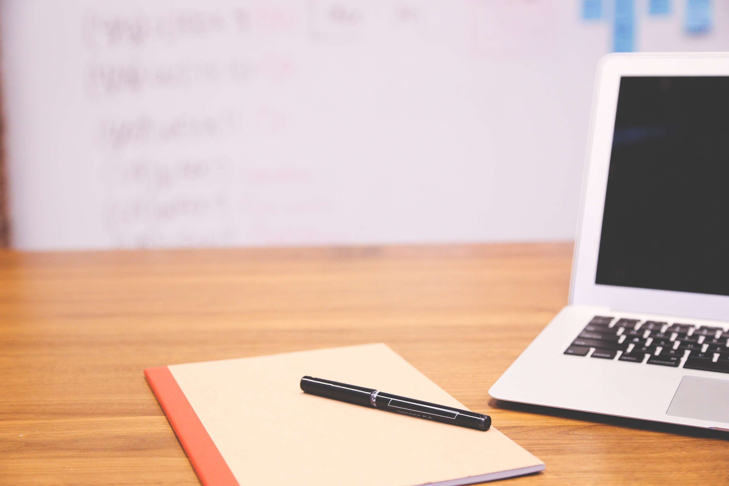 Laptop, notebook, and pen on a wooden desk HD Wallpaper
