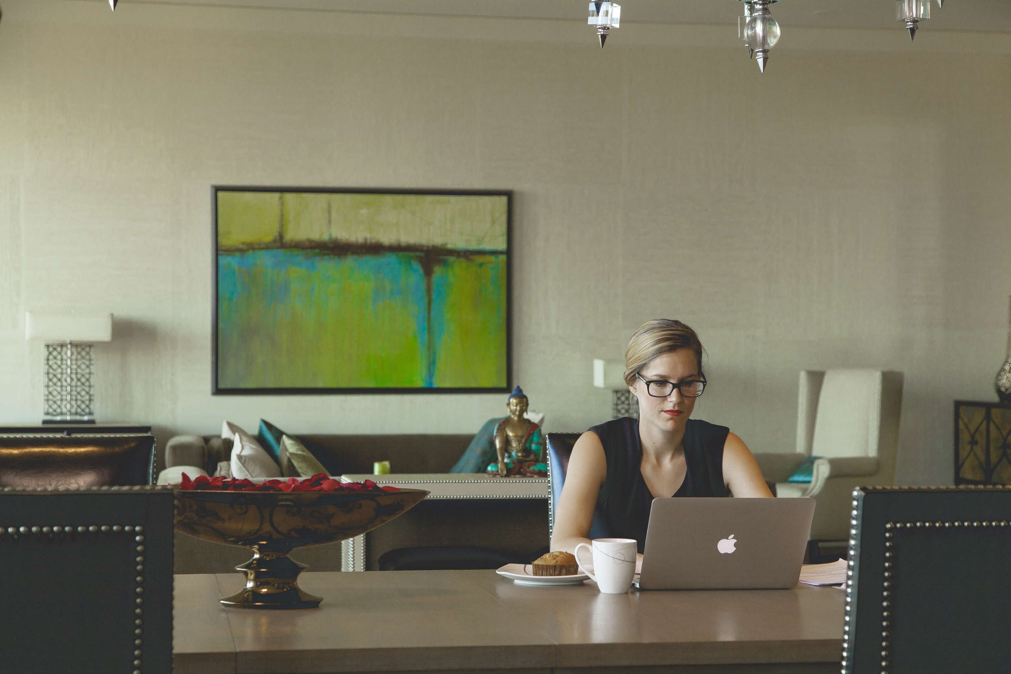 Woman working on Apple MacBook in a living room HD Wallpaper