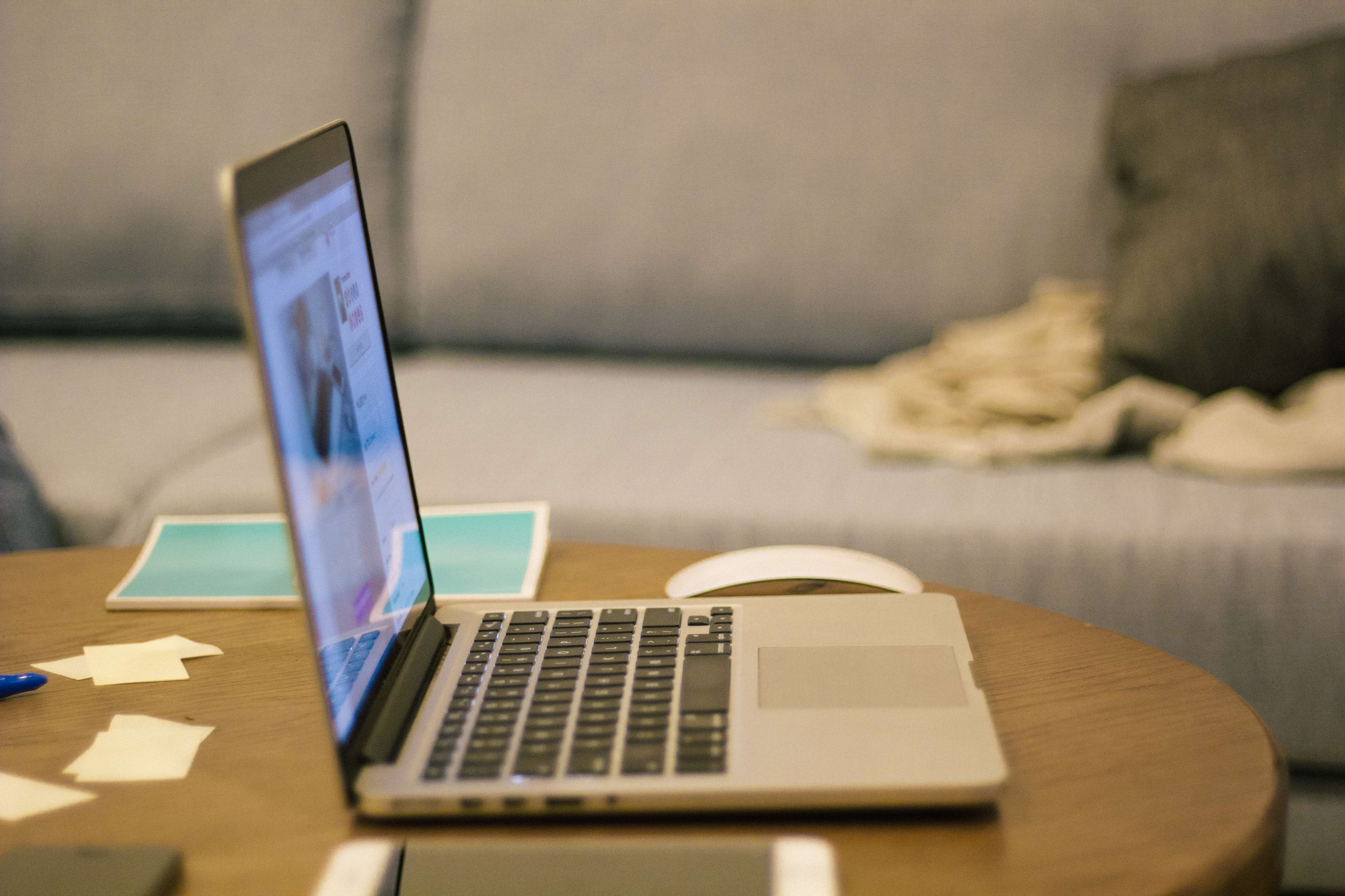 MacBook Pro on a wooden table with a mouse HD Wallpaper