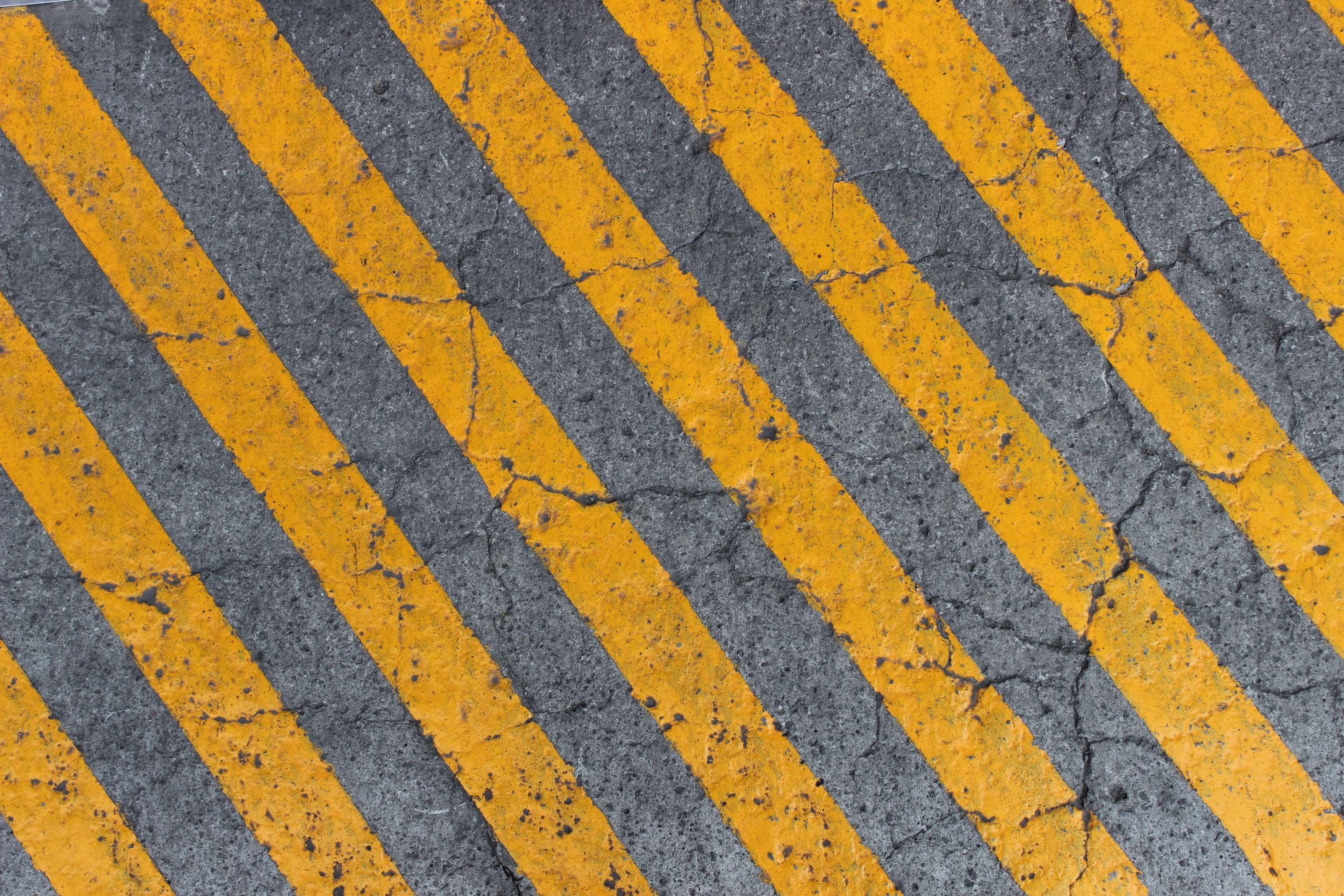Yellow and gray hazard stripes on concrete HD Wallpaper