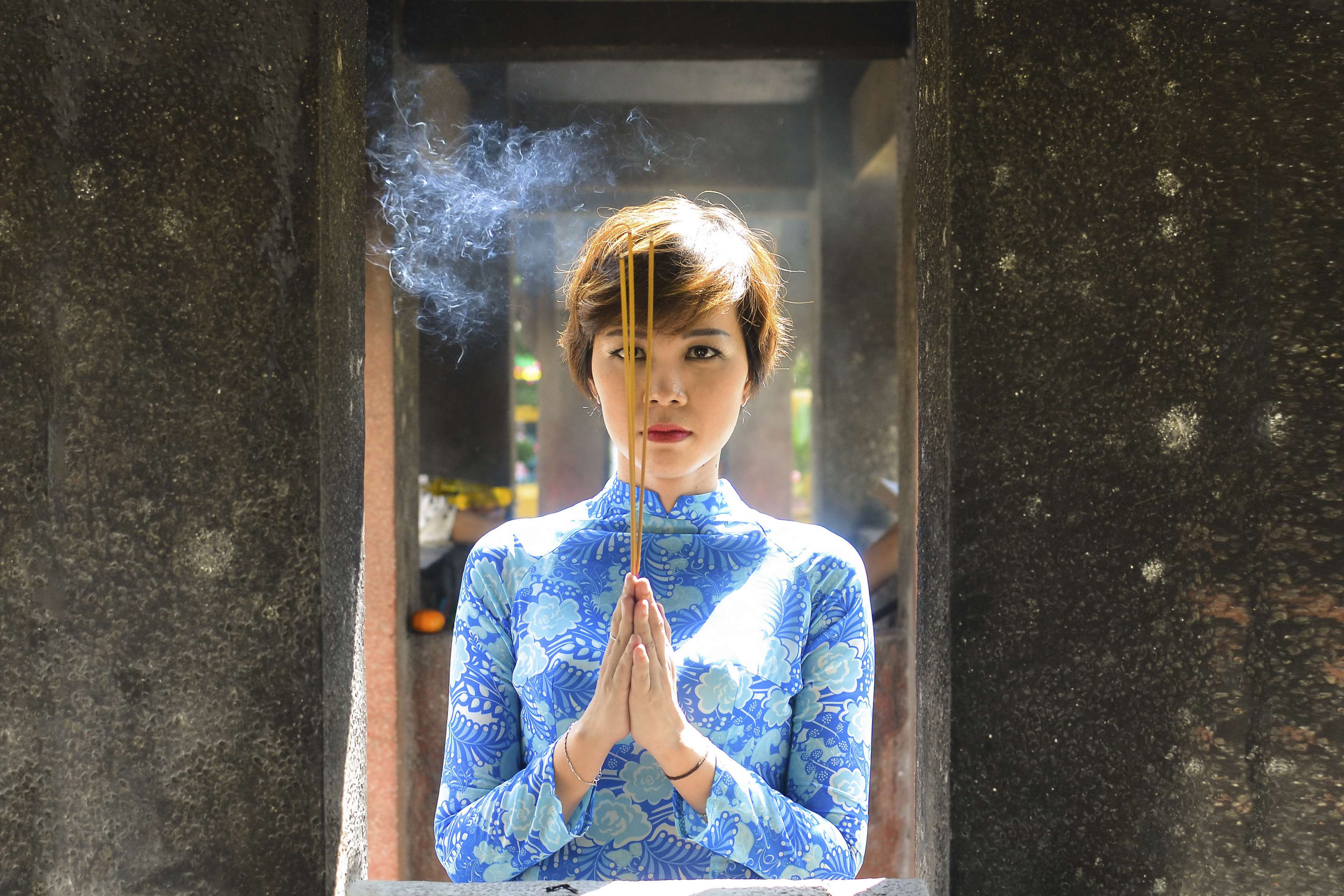 Woman praying with incense sticks in Vietnam HD Wallpaper