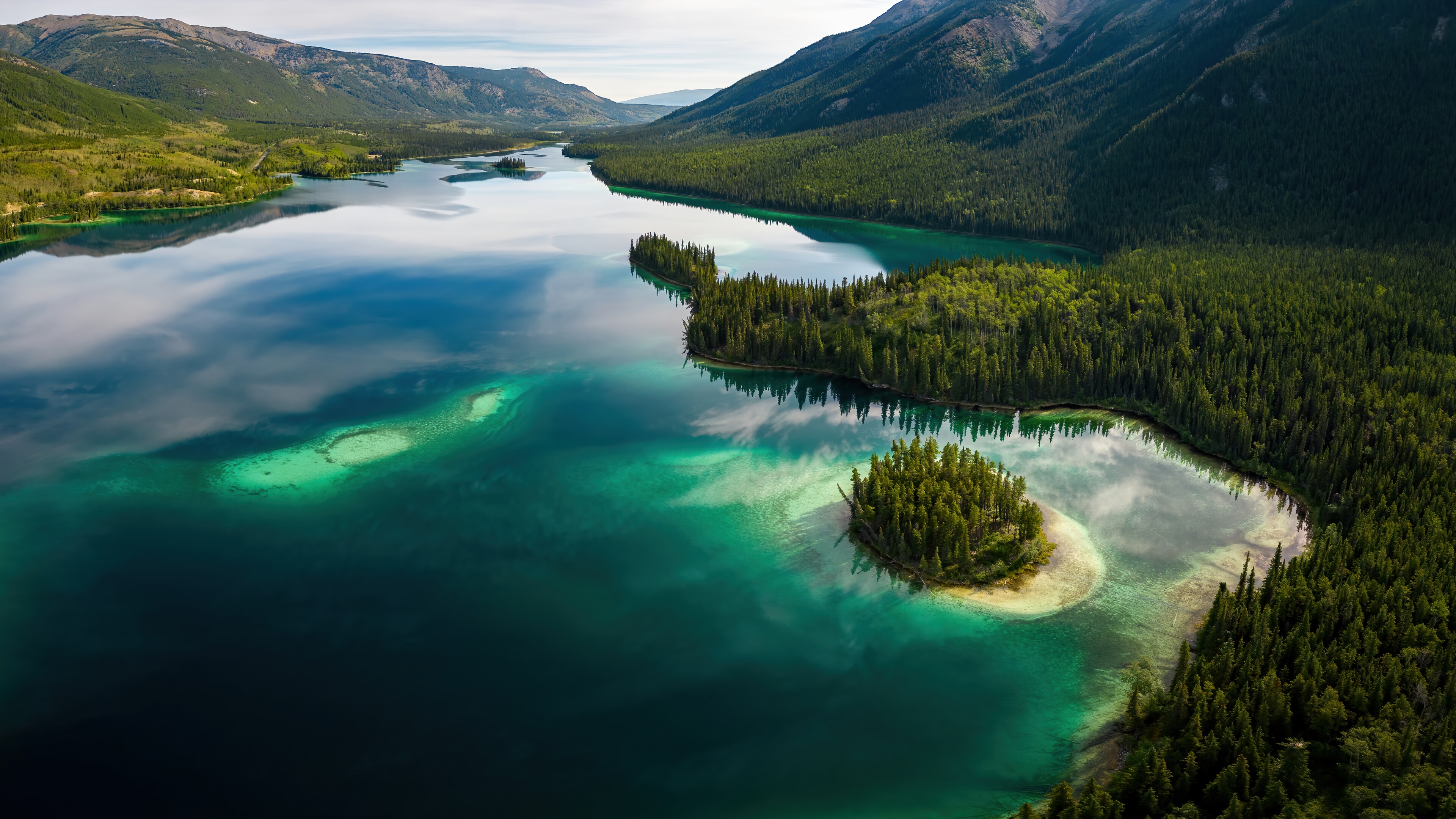 Aerial View of a Forested Lake and Mountains 4K HD Wallpaper