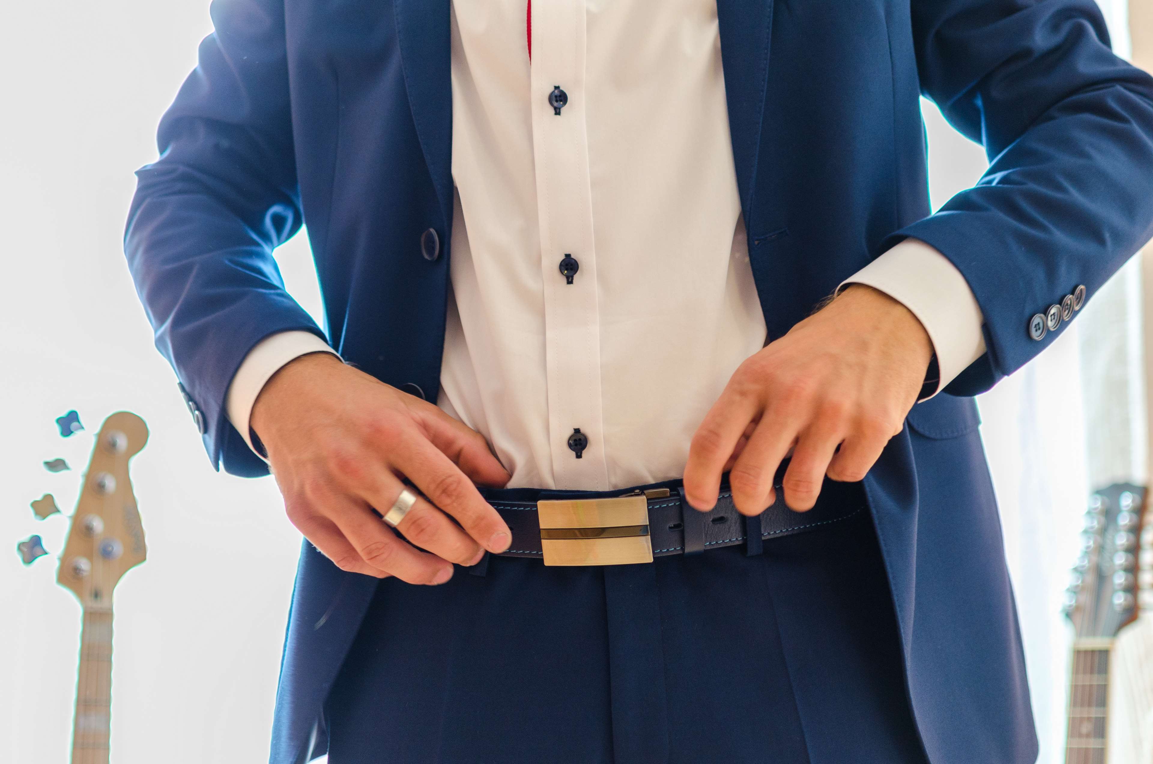Man in a suit adjusting his belt HD Wallpaper