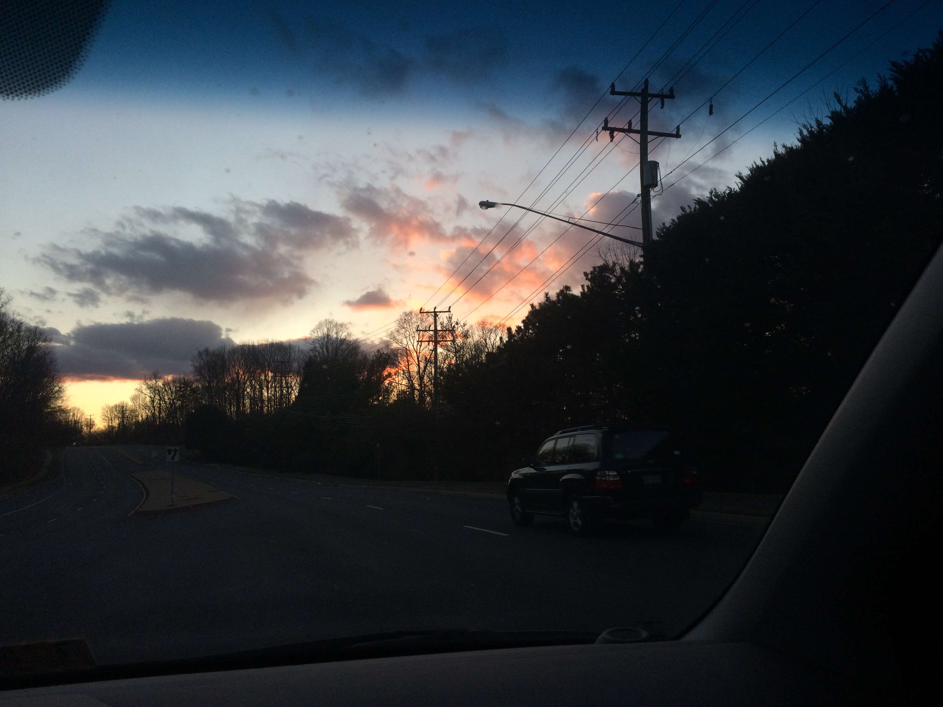 Car driving on road at sunset with power lines HD Wallpaper