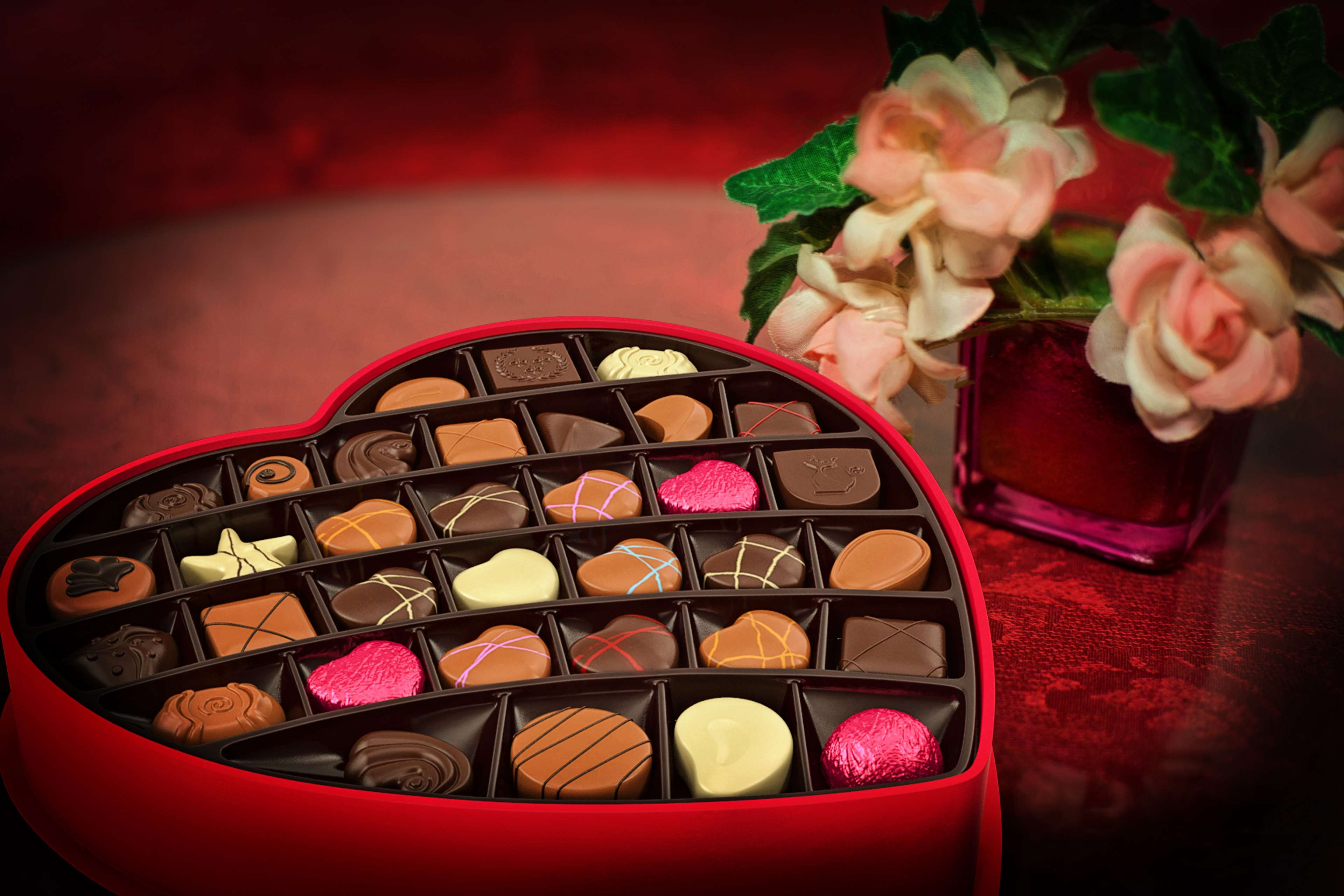 Heart-shaped box of assorted chocolates with flowers HD Wallpaper
