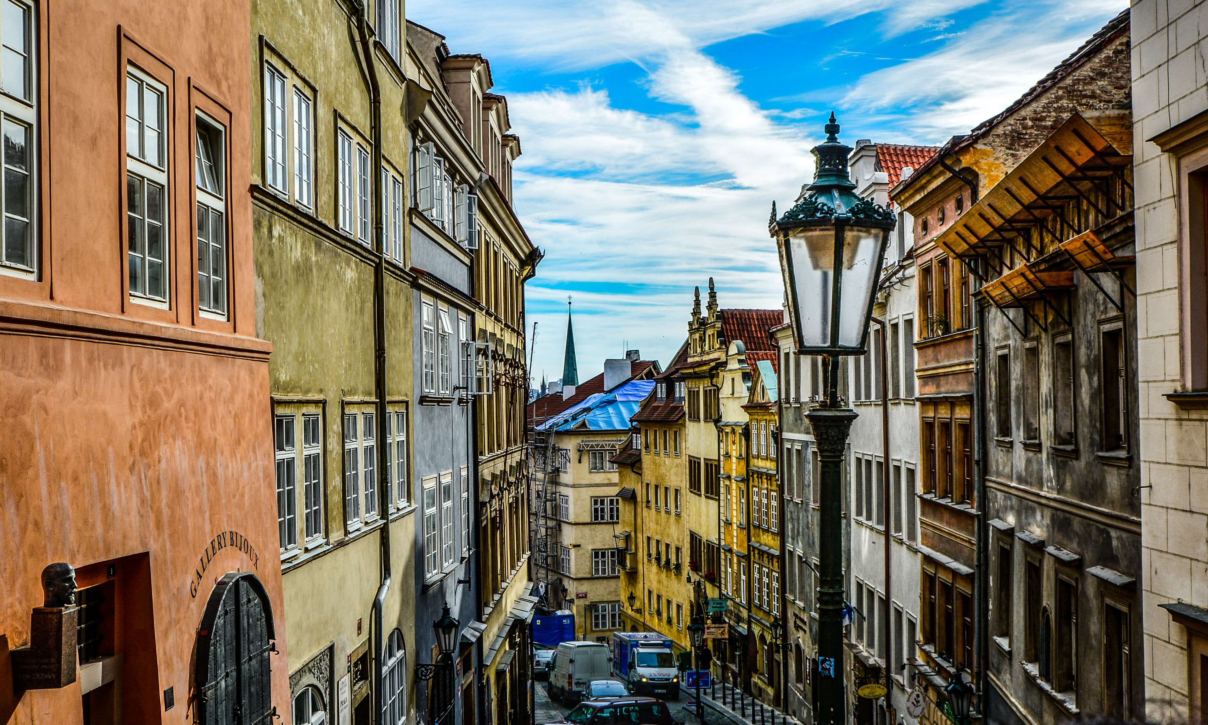 Narrow European street with colorful buildings and a street lamp HD Wallpaper