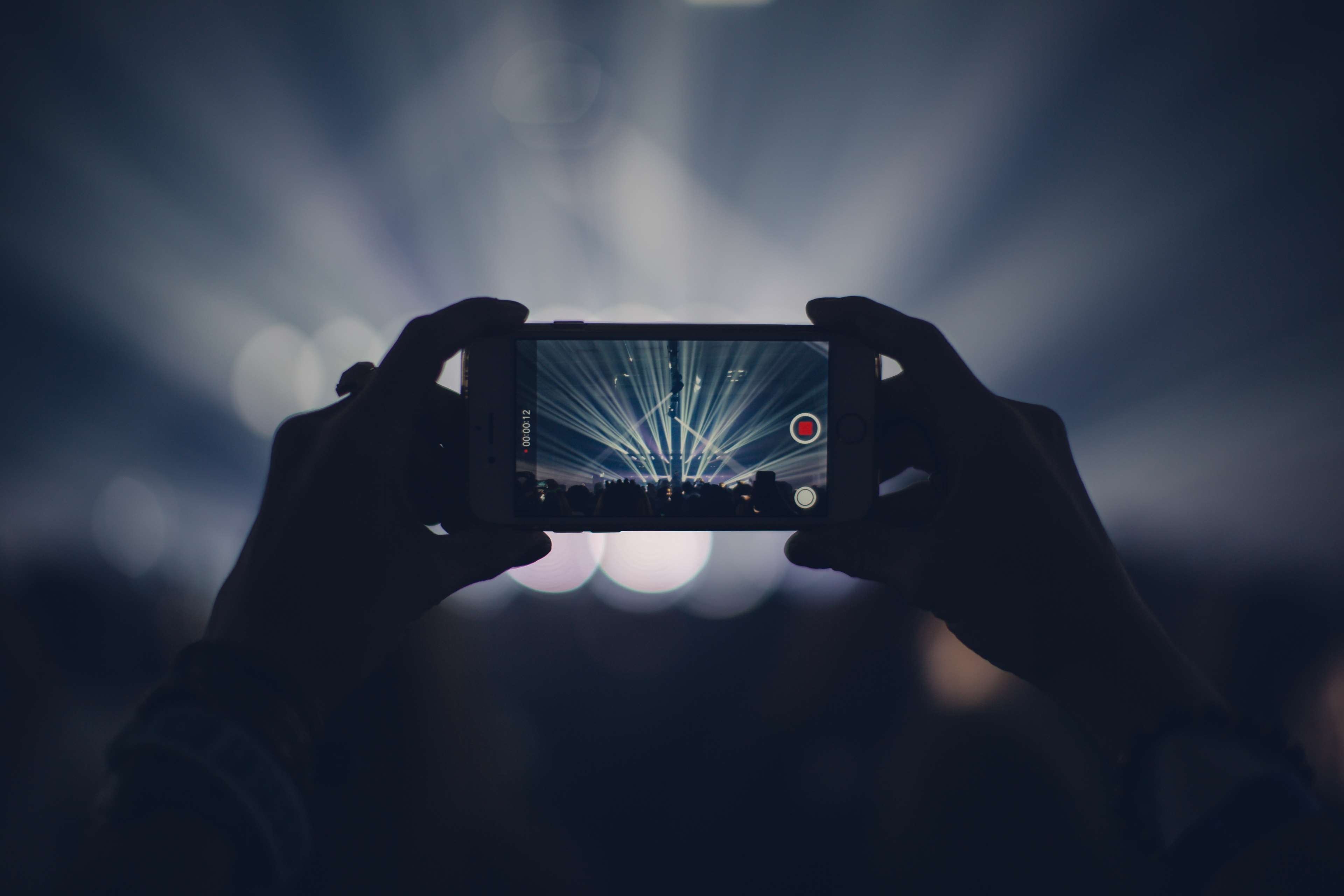 Person filming concert lights on iPhone HD Wallpaper