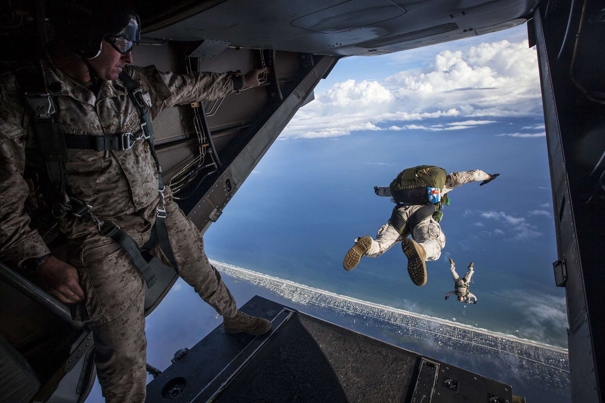 Marines jump from a plane over the ocean HD Wallpaper
