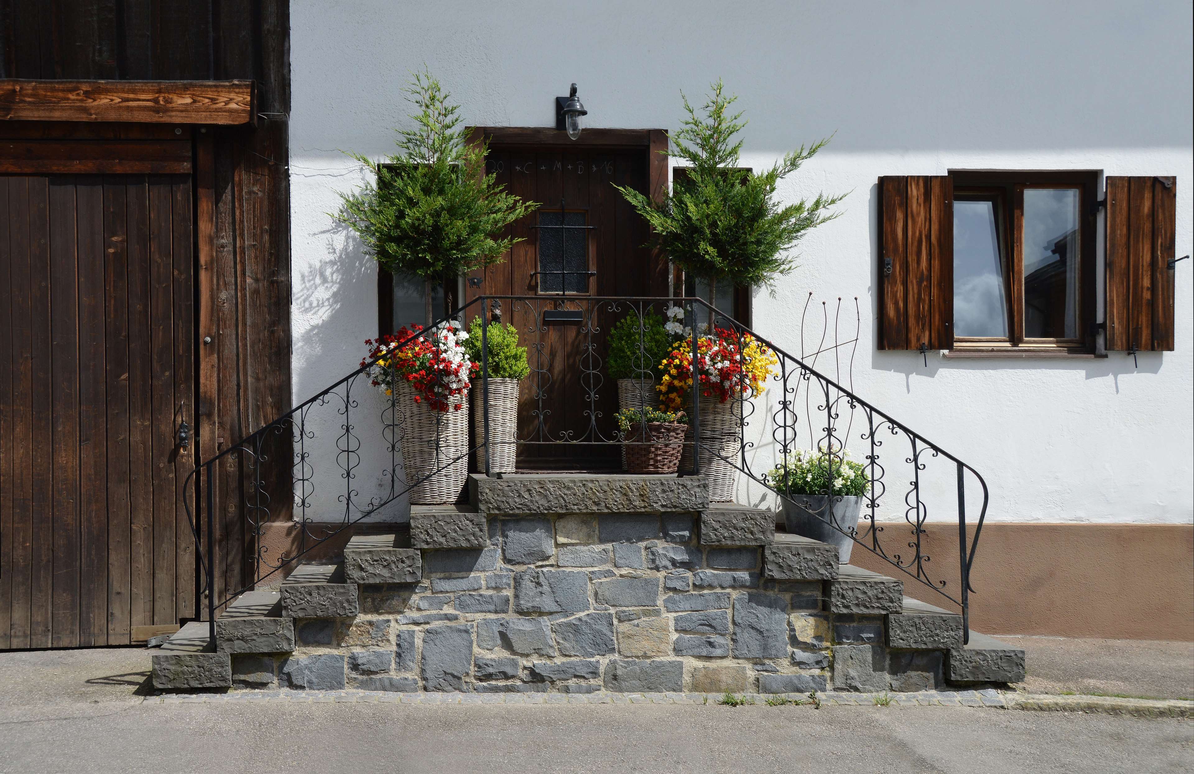 Rustic house entrance with stone stairs and flower pots HD Wallpaper