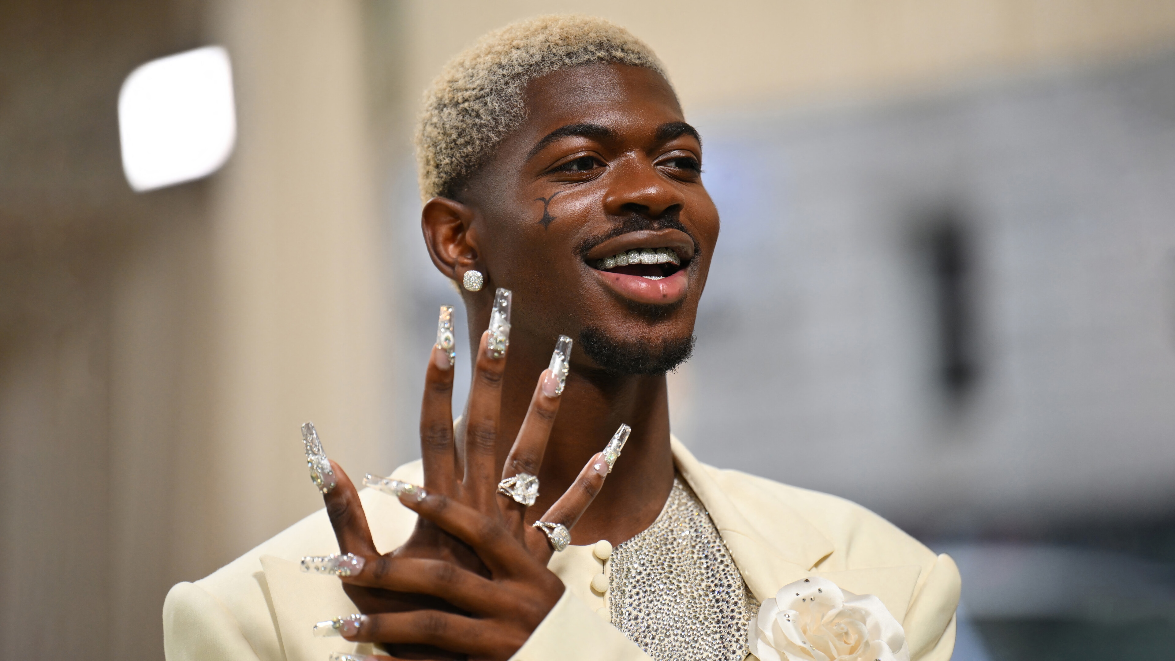Lil Nas X in a cream suit with long jeweled nails HD Wallpaper