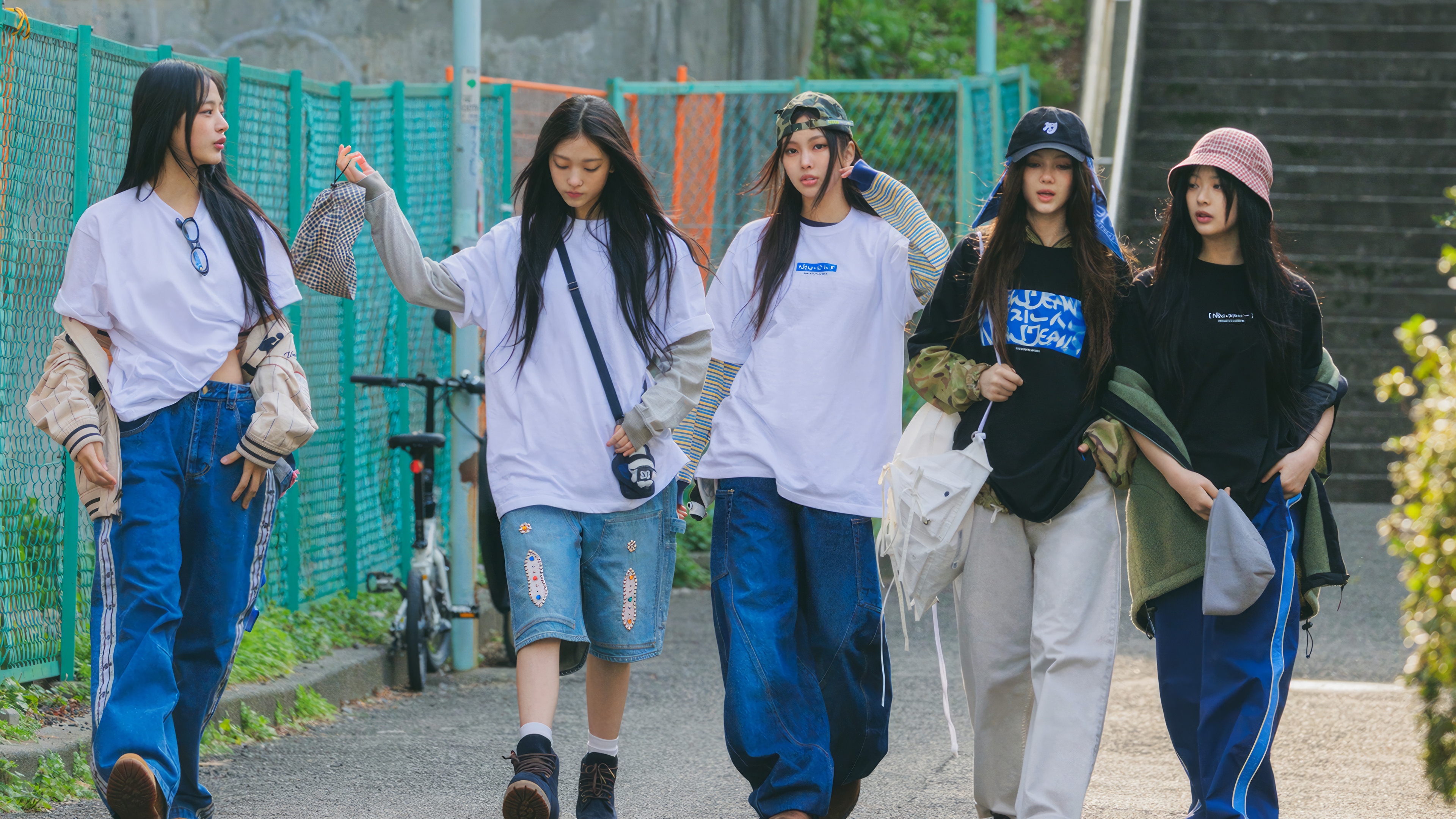 NewJeans members walking outdoors HD Wallpaper