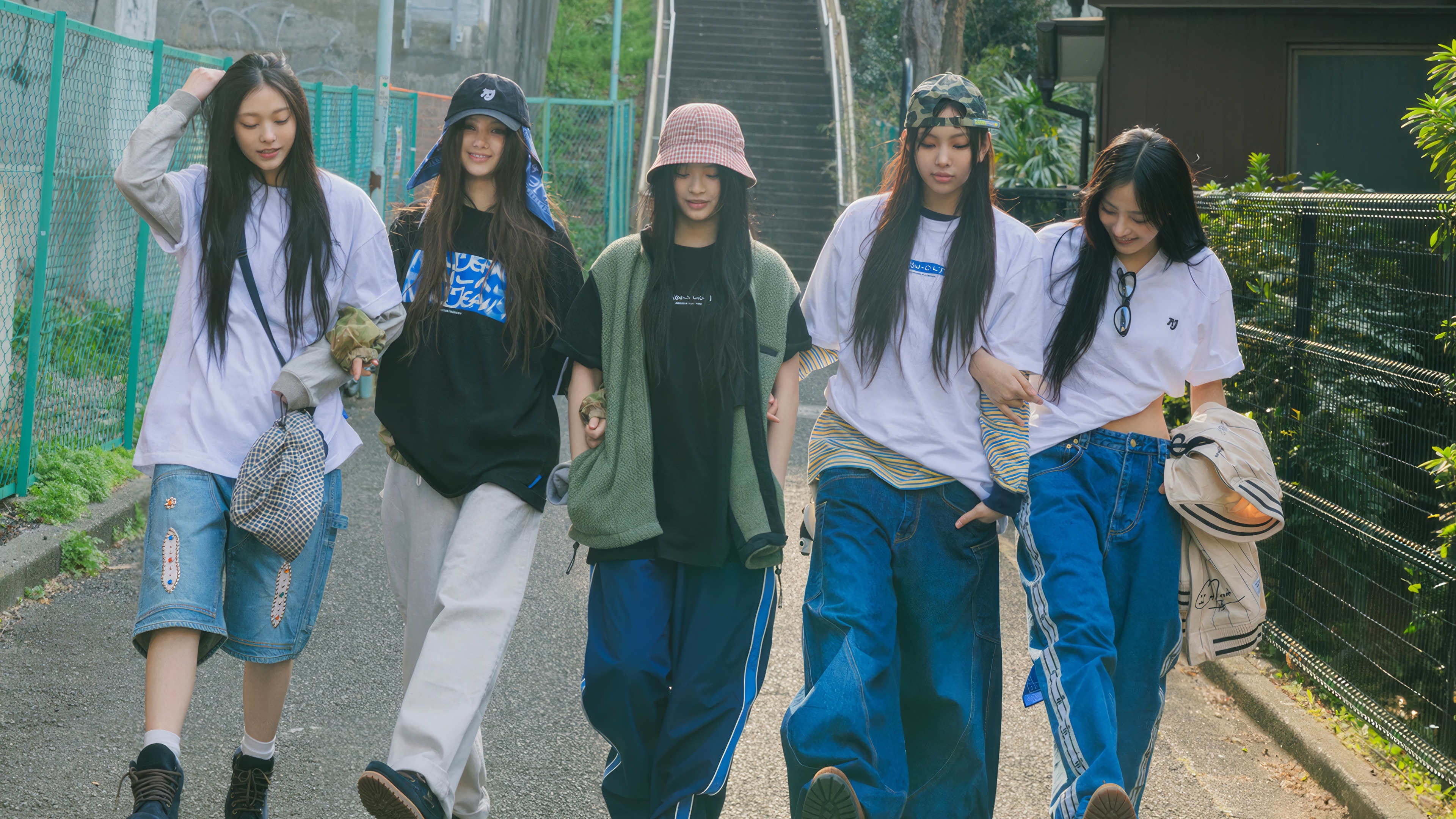 NewJeans members walking on a street HD Wallpaper
