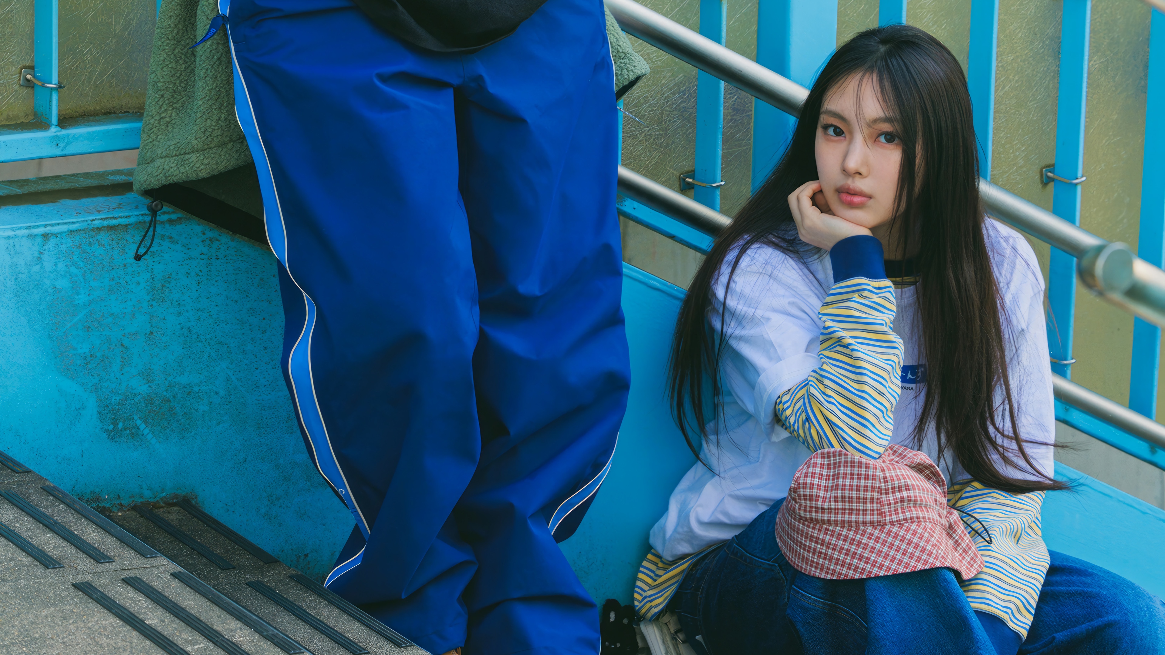 Hyein from NewJeans sitting on blue stairs HD Wallpaper