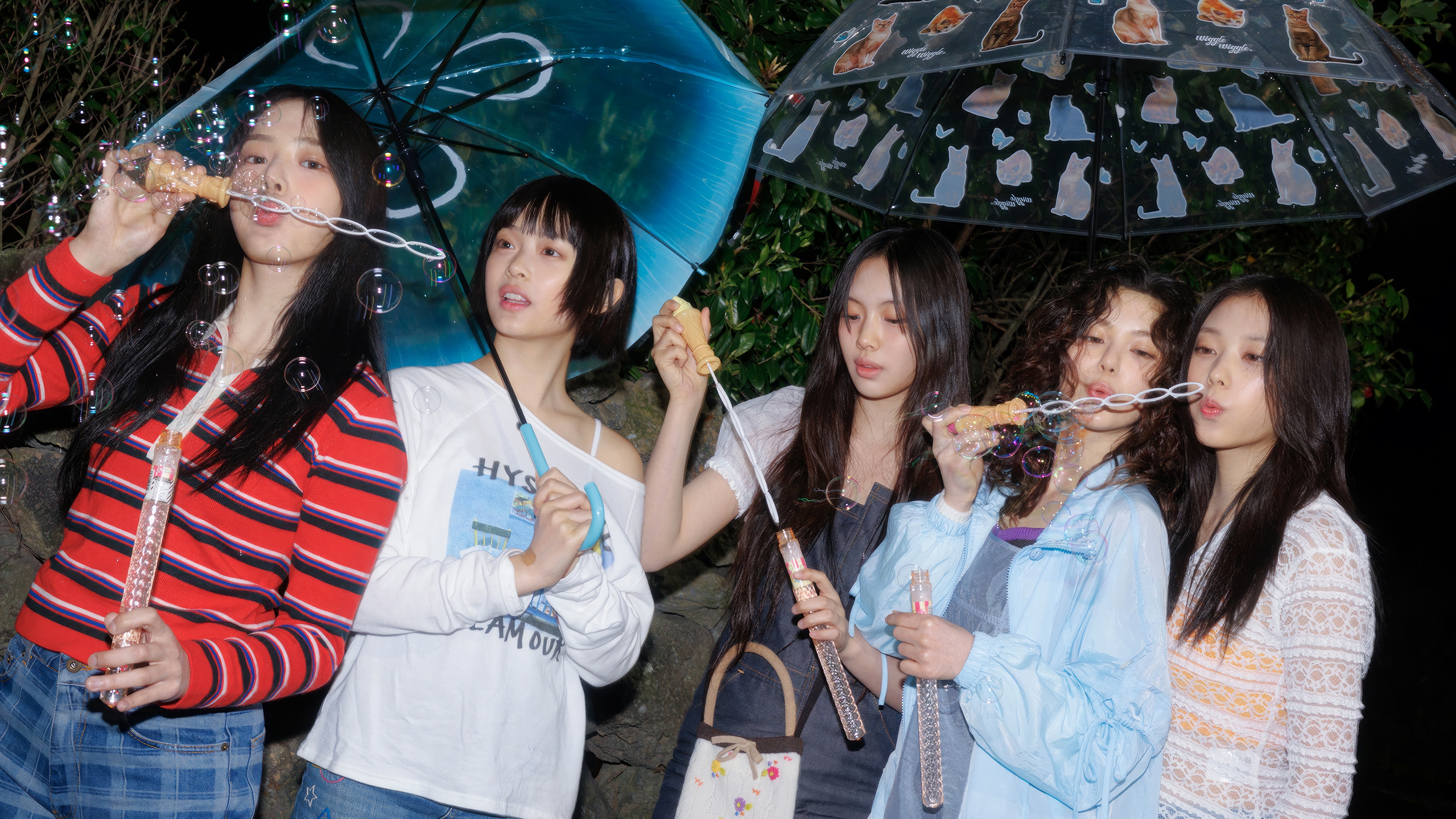NewJeans blowing bubbles under umbrellas HD Wallpaper