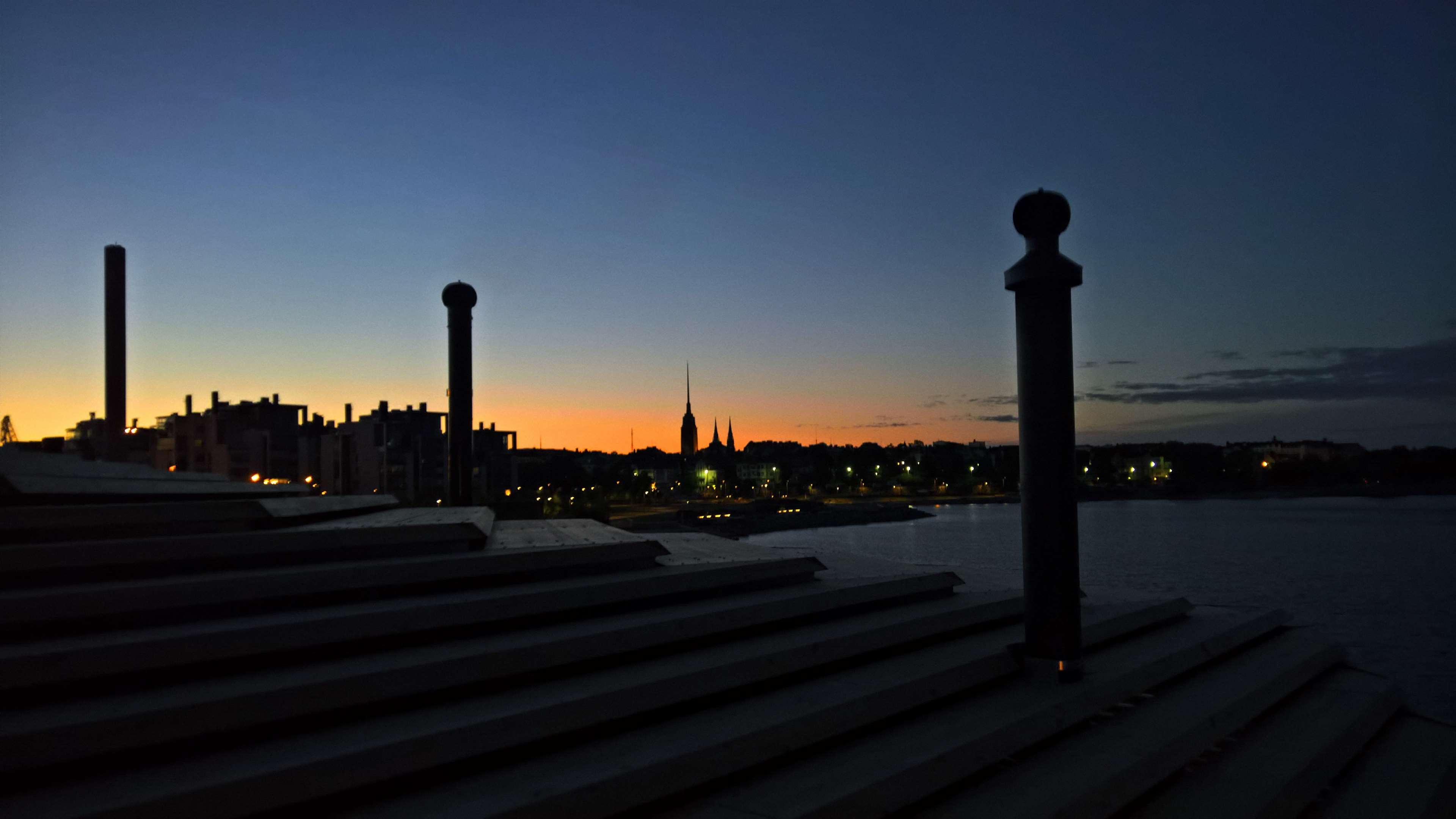 Helsinki skyline at dusk with Lyly rooftop in foreground HD Wallpaper