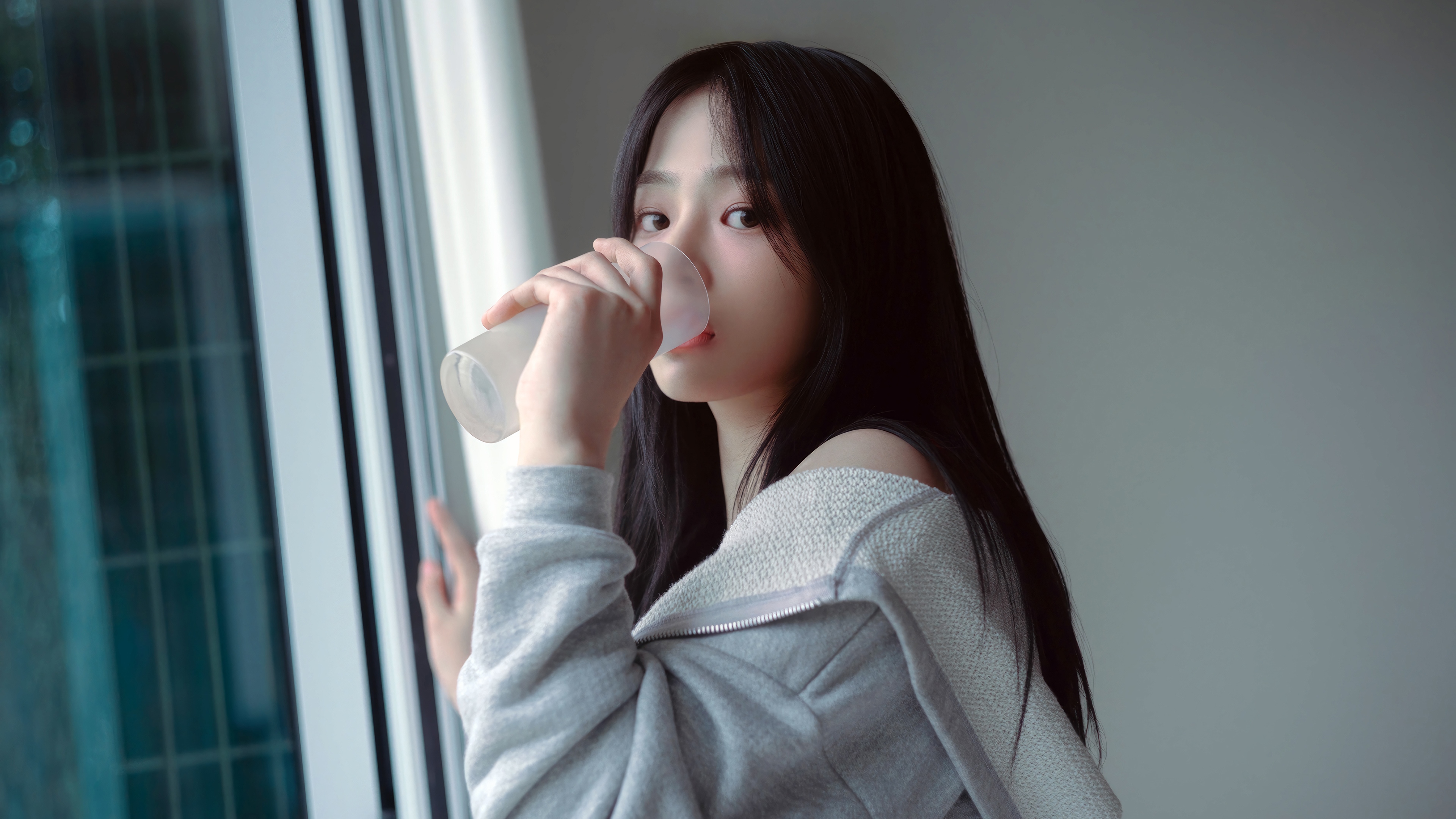 Minji from NewJeans drinking from a cup HD Wallpaper
