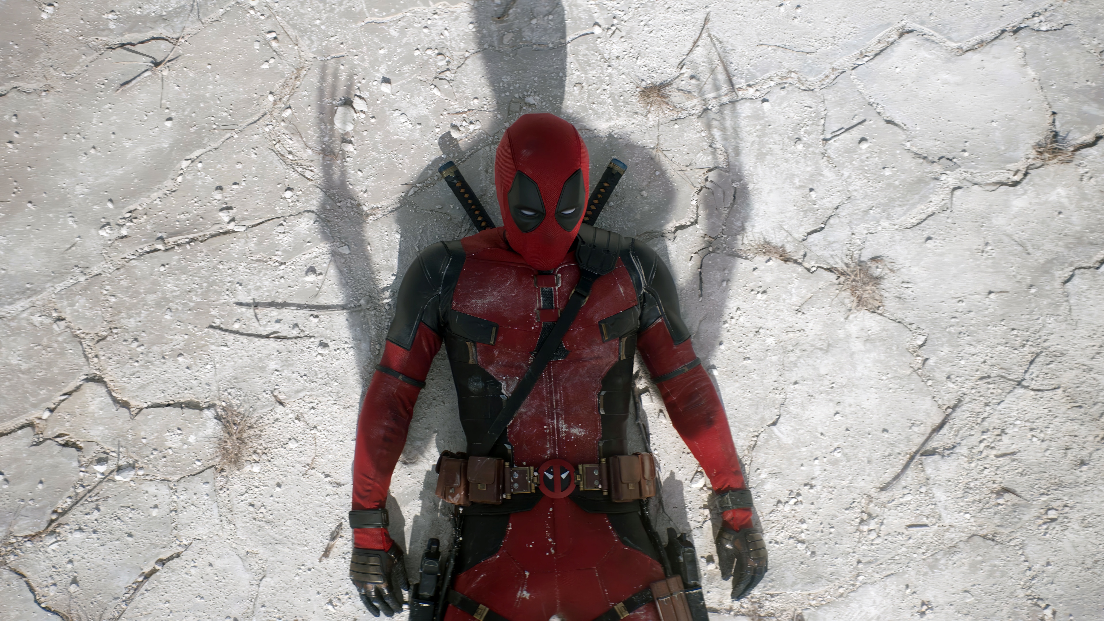 Deadpool lying on cracked ground HD Wallpaper
