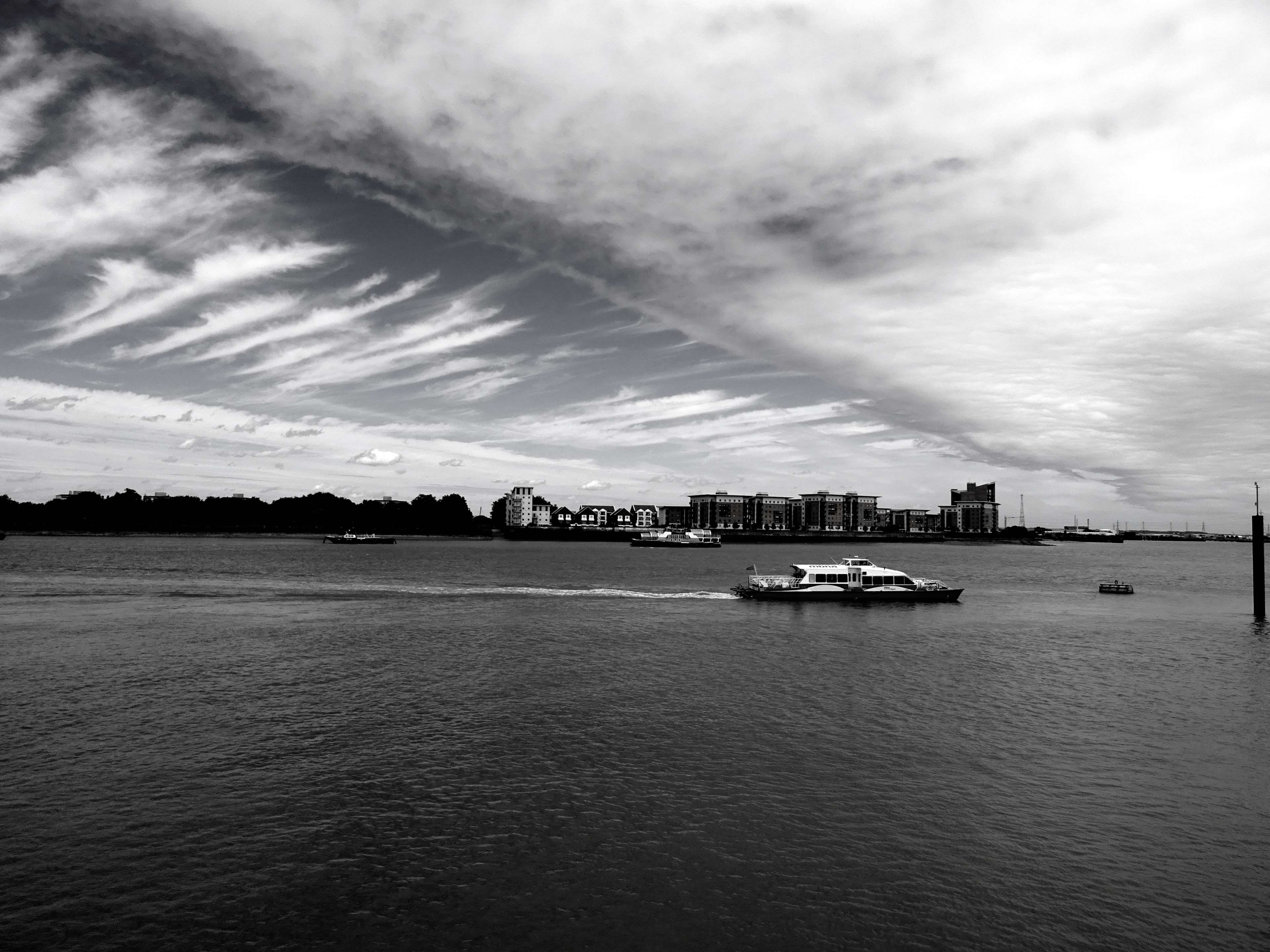 Black and white cityscape with boats on the water HD Wallpaper