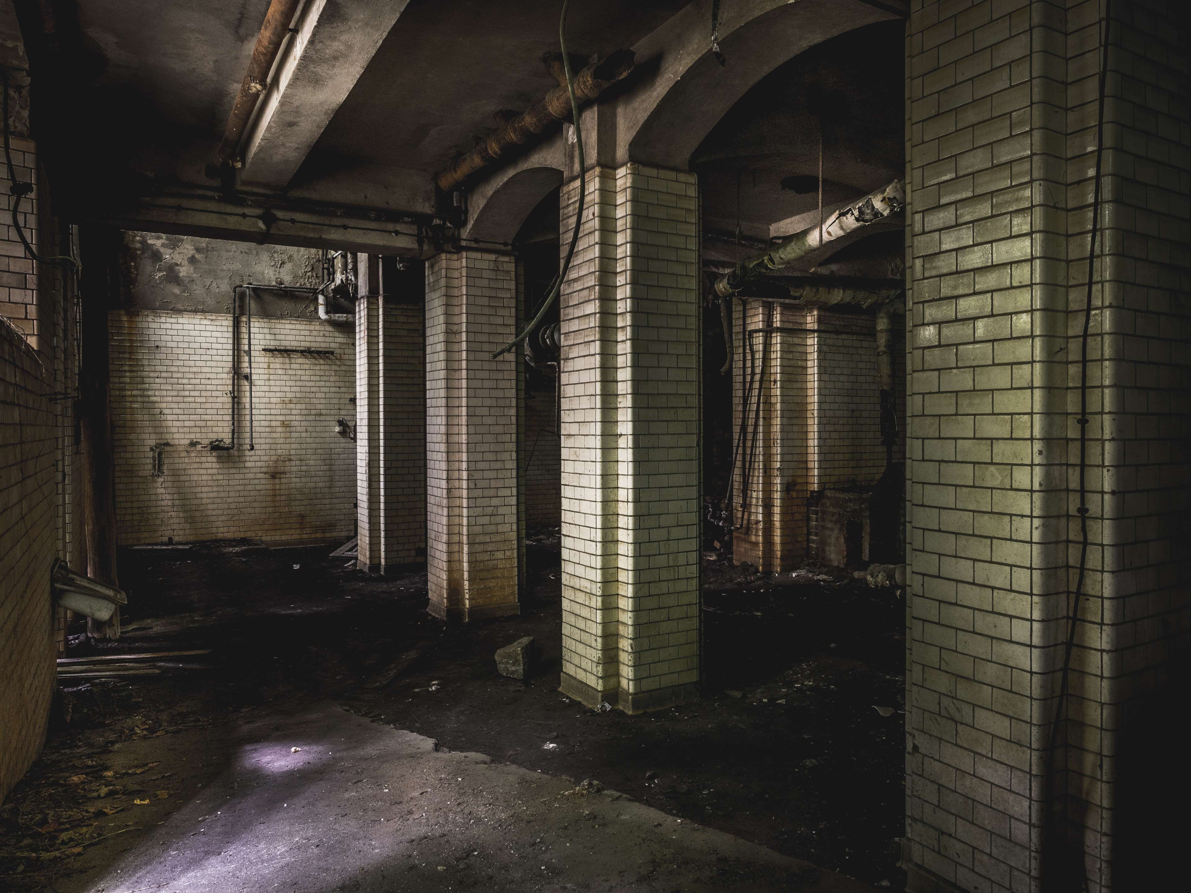 Abandoned building interior with arches and tiled columns HD Wallpaper