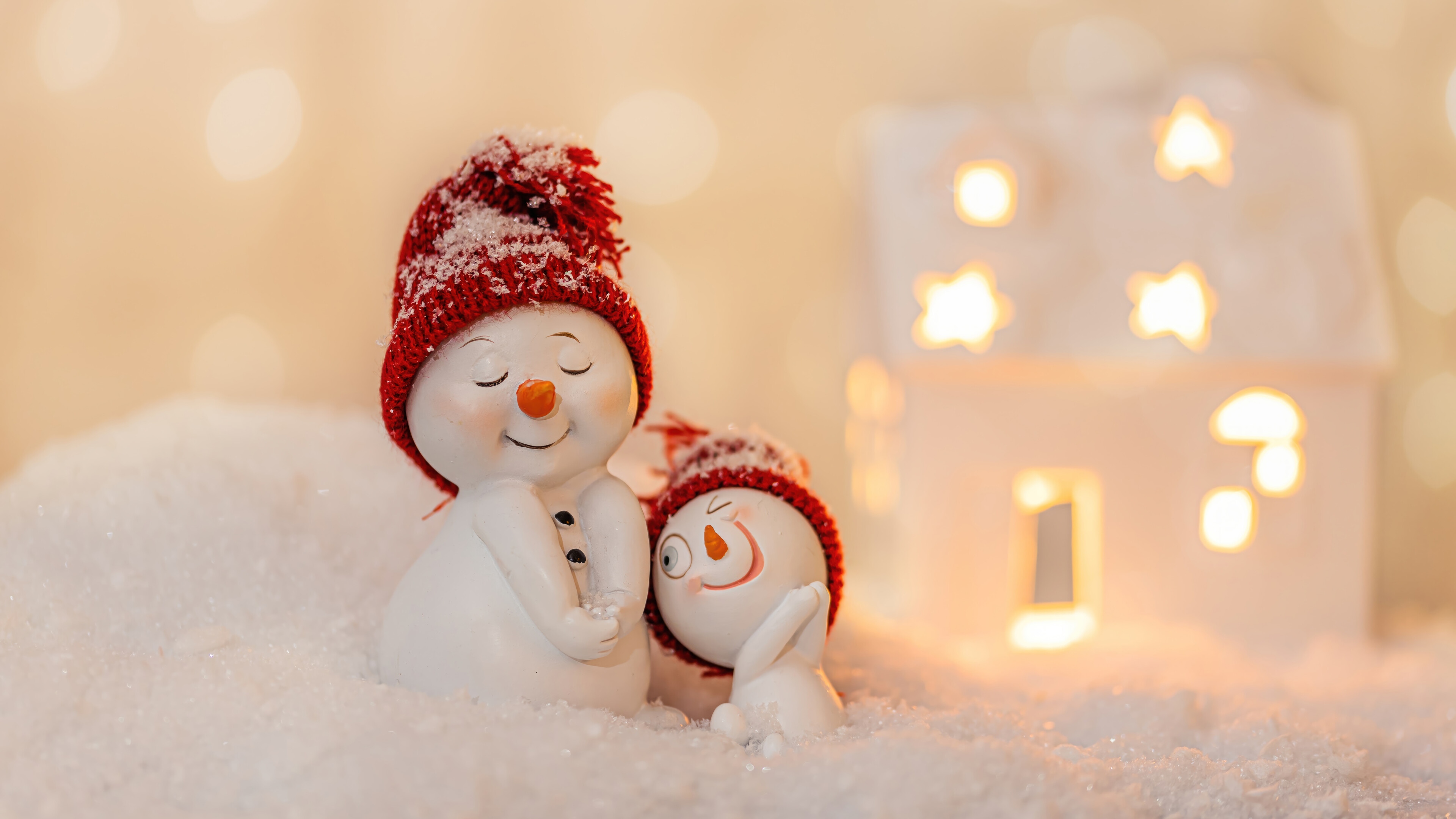 Two snowmen in red hats with a Christmas house HD Wallpaper