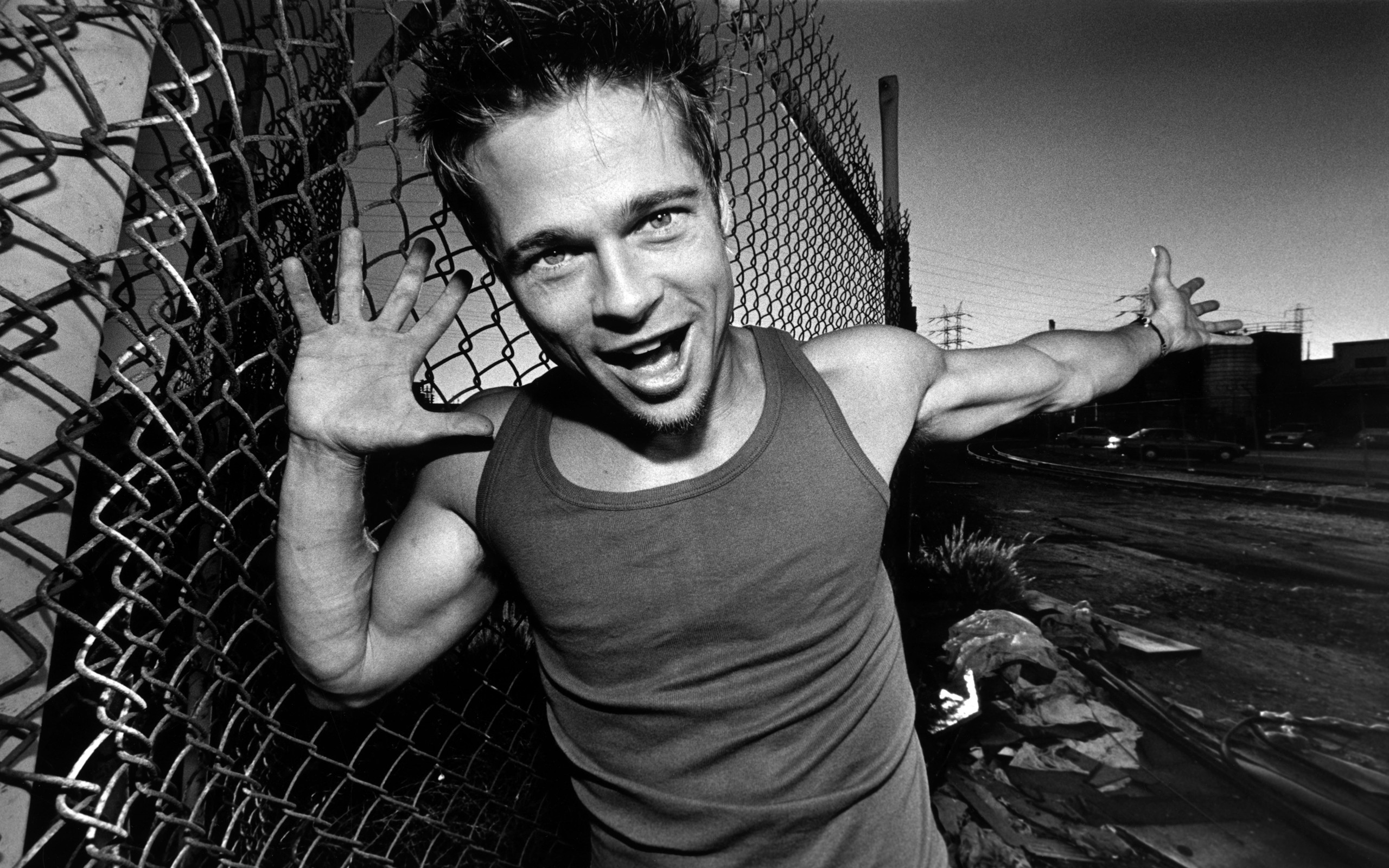 Brad Pitt posing by a chain-link fence HD Wallpaper