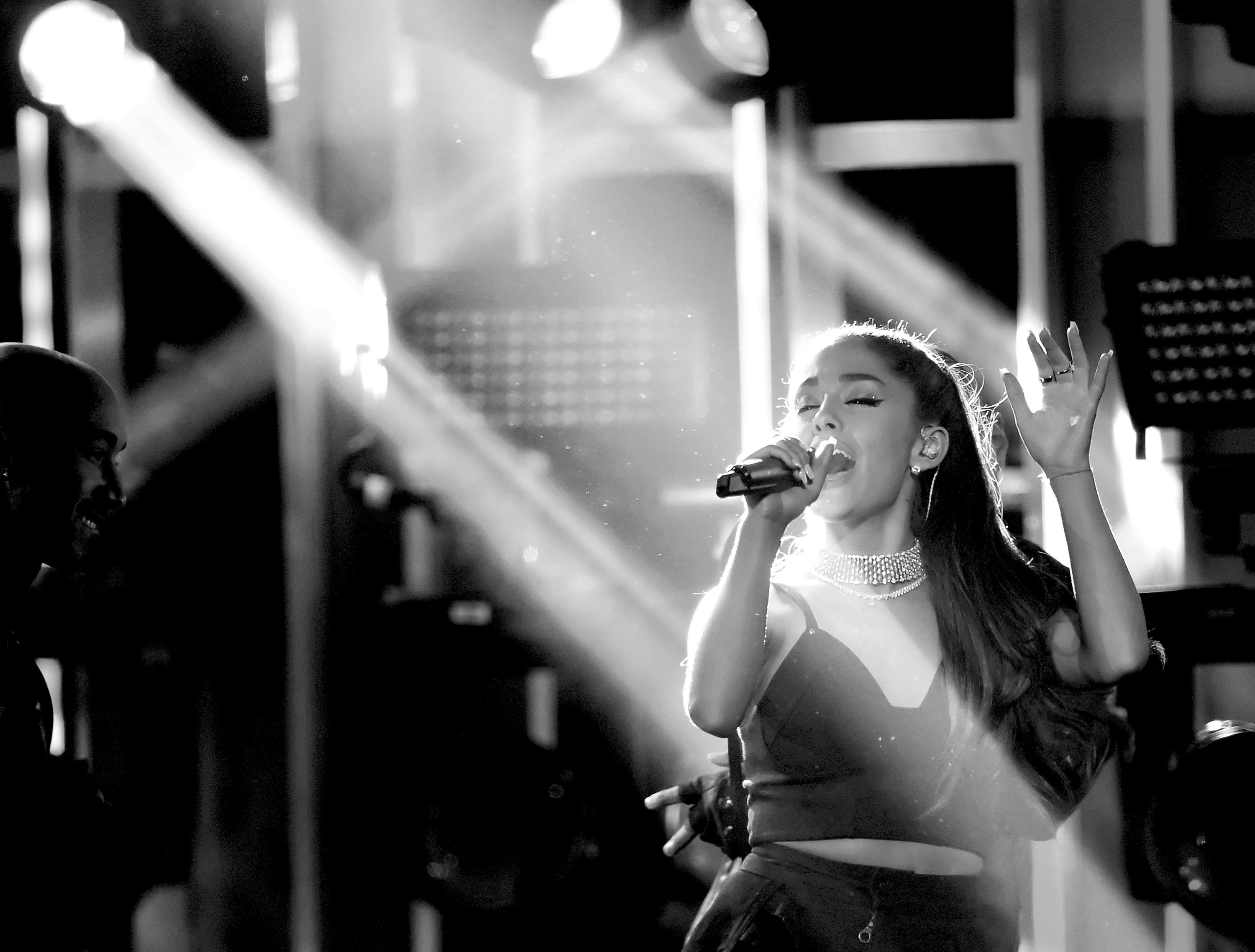 Ariana Grande performing on stage with spotlights HD Wallpaper