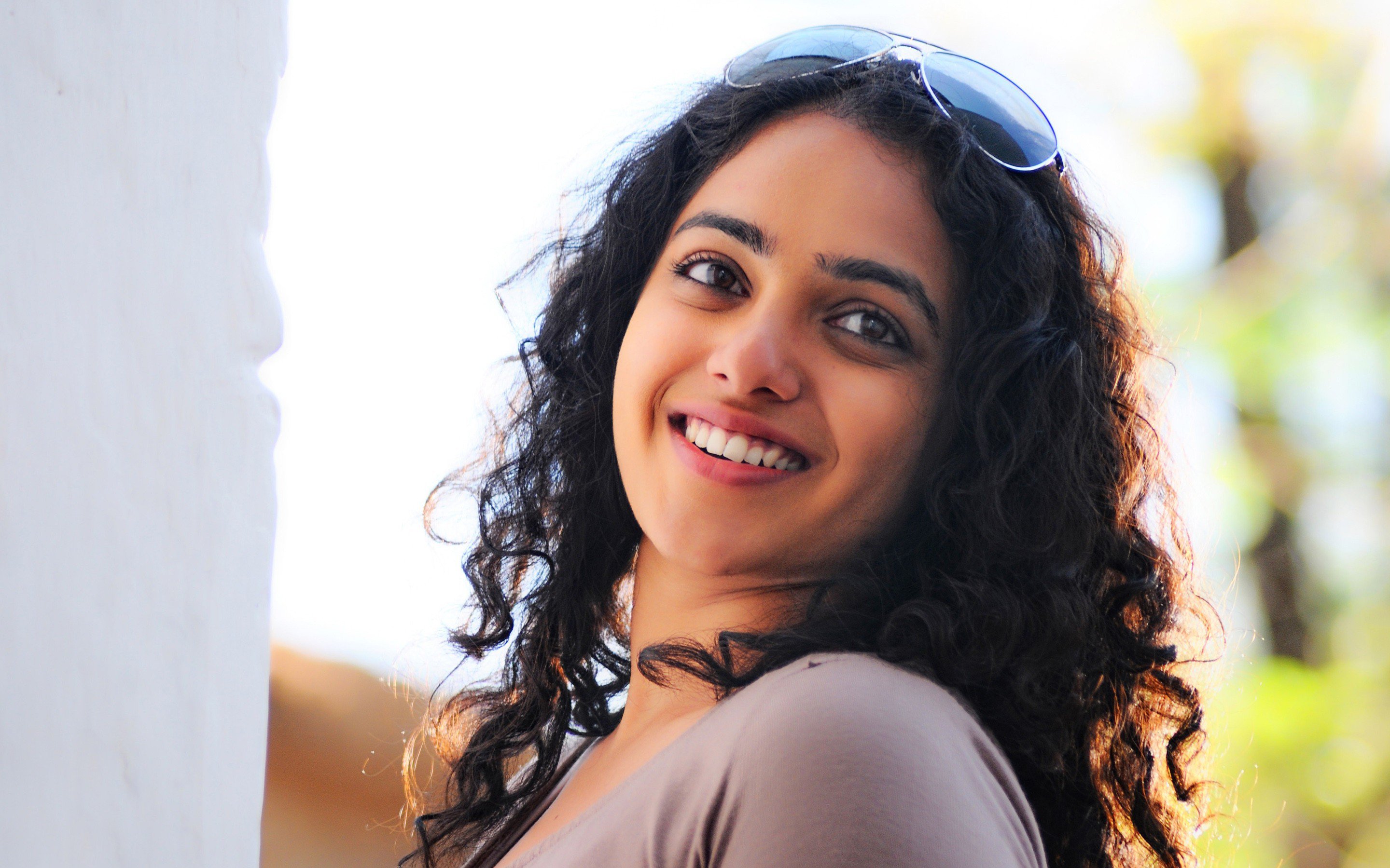 Nithya Menon smiling with sunglasses HD Wallpaper