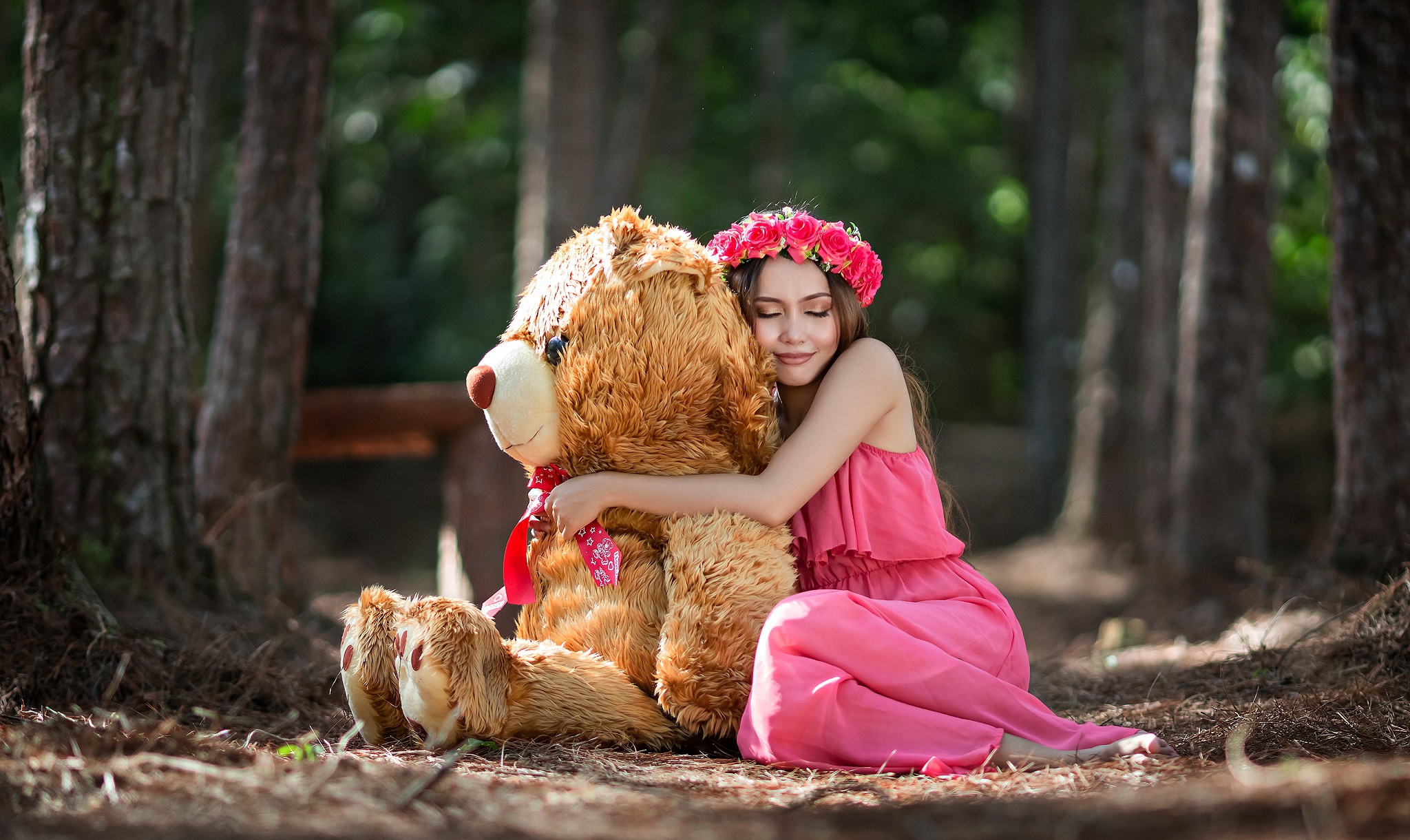 Girl Embracing Teddy Bear in Forest Setting HD Wallpaper