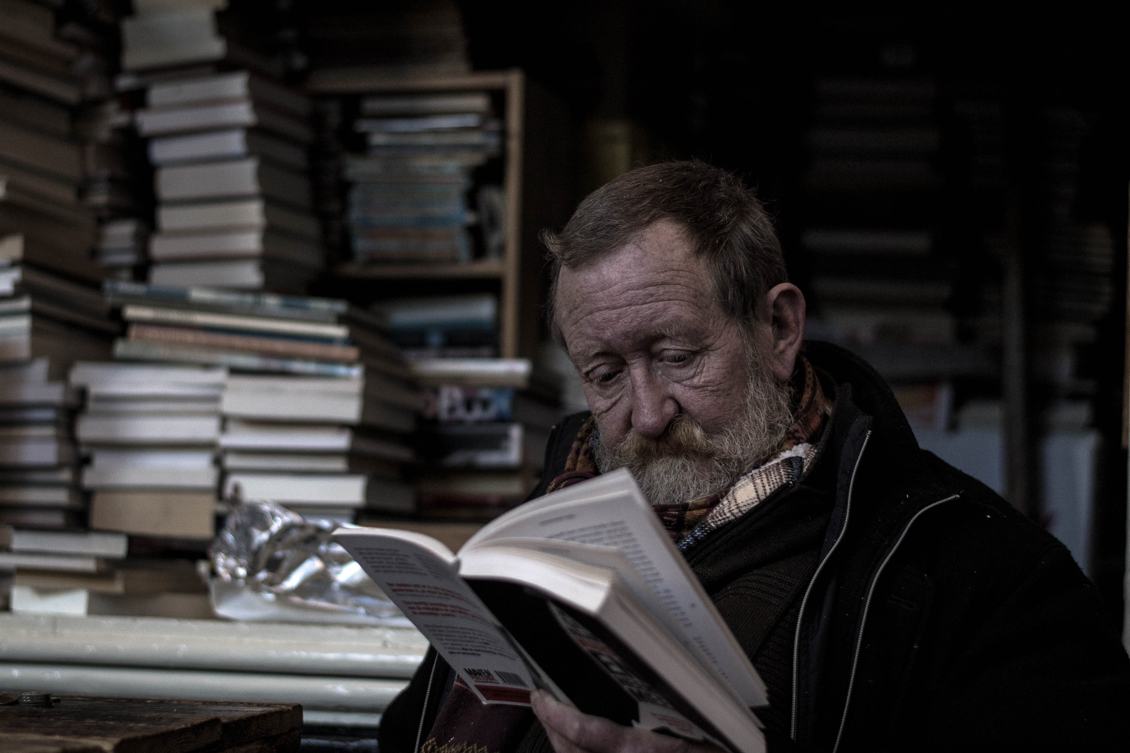 Elderly man reading a book in a bookstore HD Wallpaper