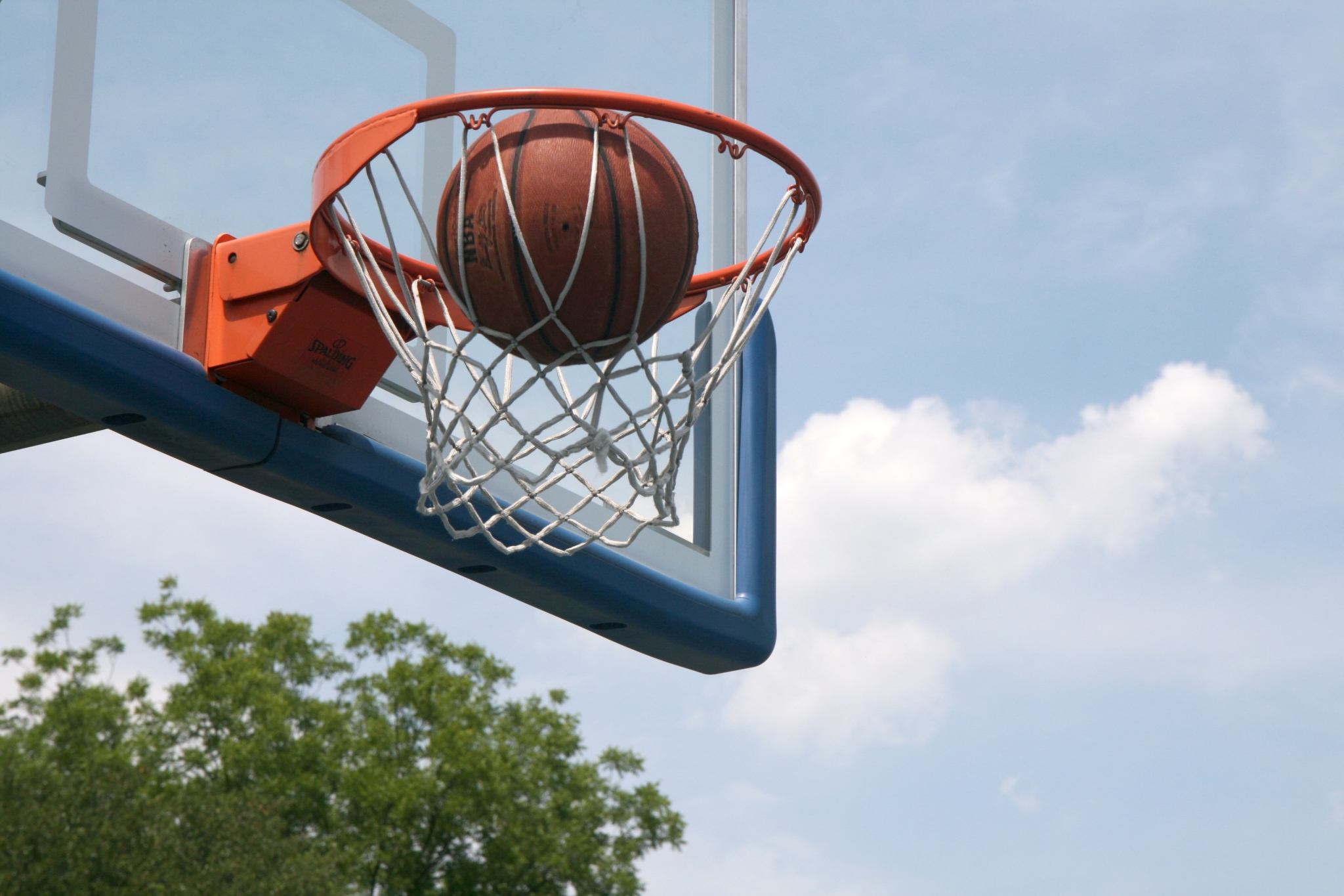 Basketball going through a hoop HD Wallpaper