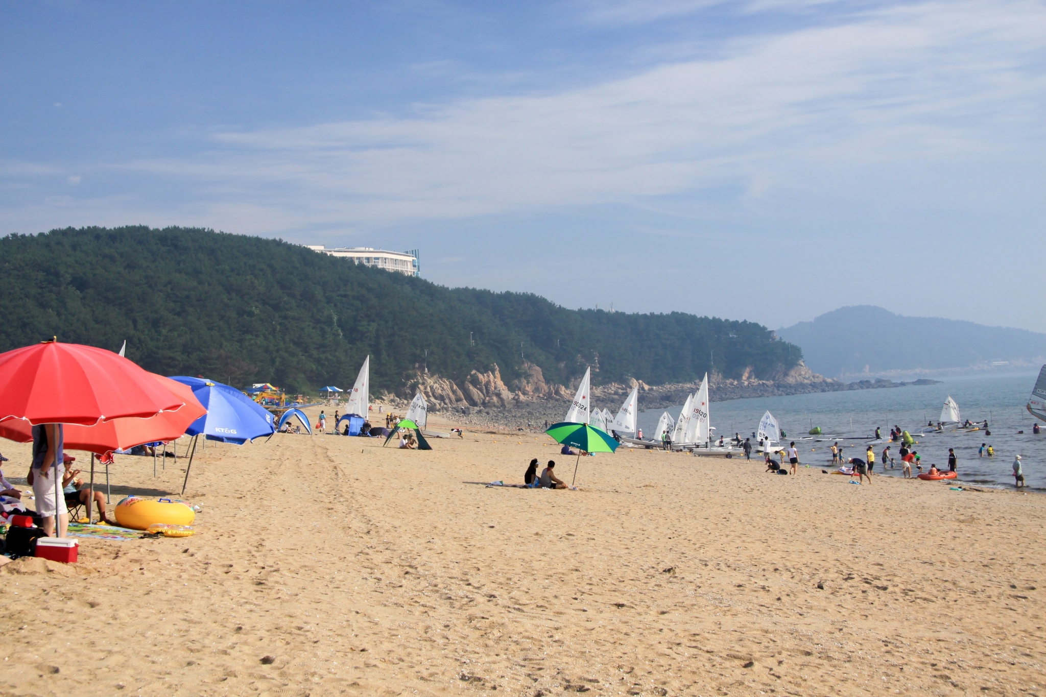 Beach with sailboats and people HD Wallpaper