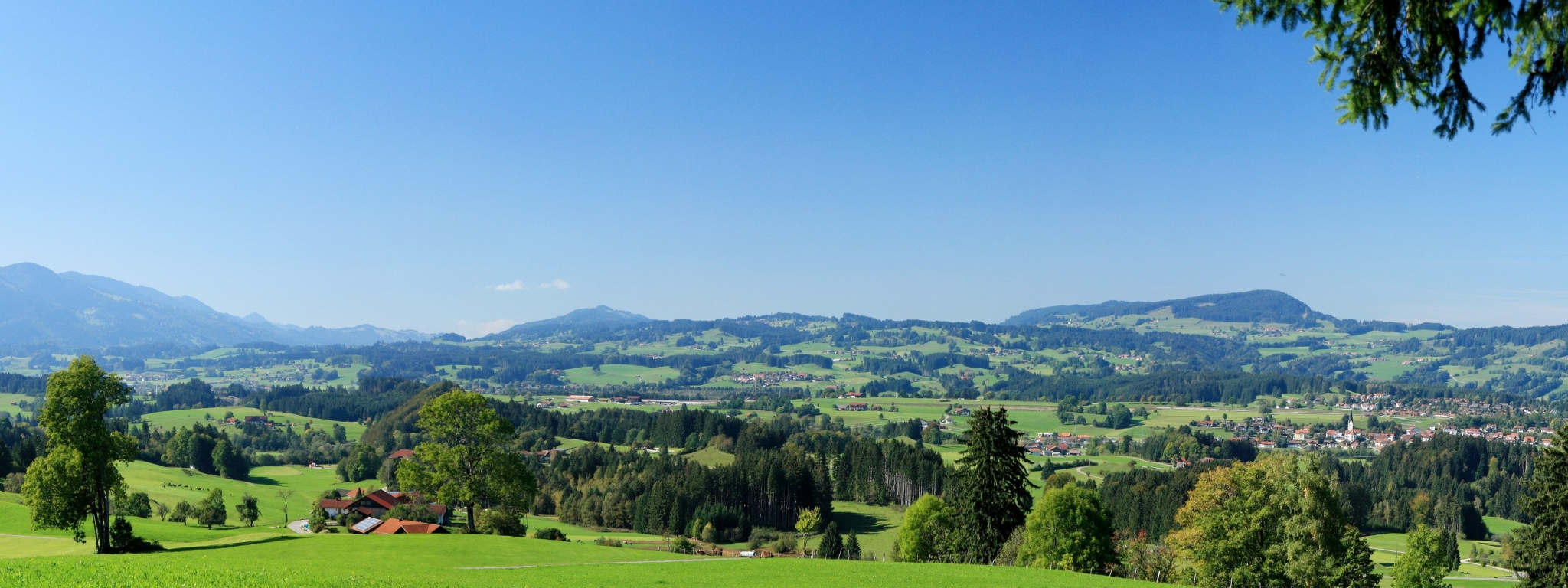 Panoramic view of rolling green hills and mountains HD Wallpaper